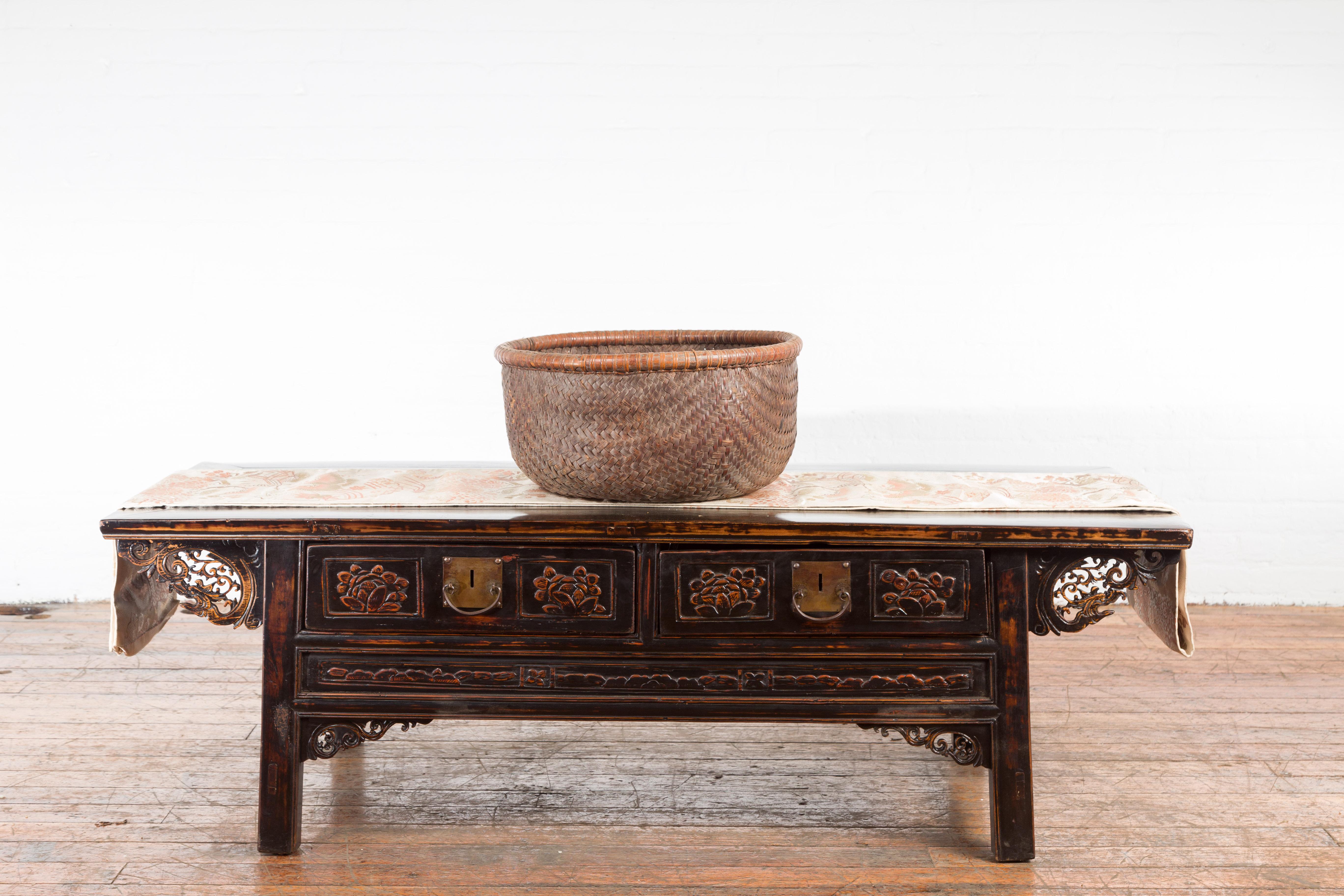A Chinese Qing Dynasty antique rattan round grain basket from the 19th century, with nice patina. Created in China during the 19h century, this grain basket features a thin lip sitting above a brown woven rattan body. With its rustic appeal and