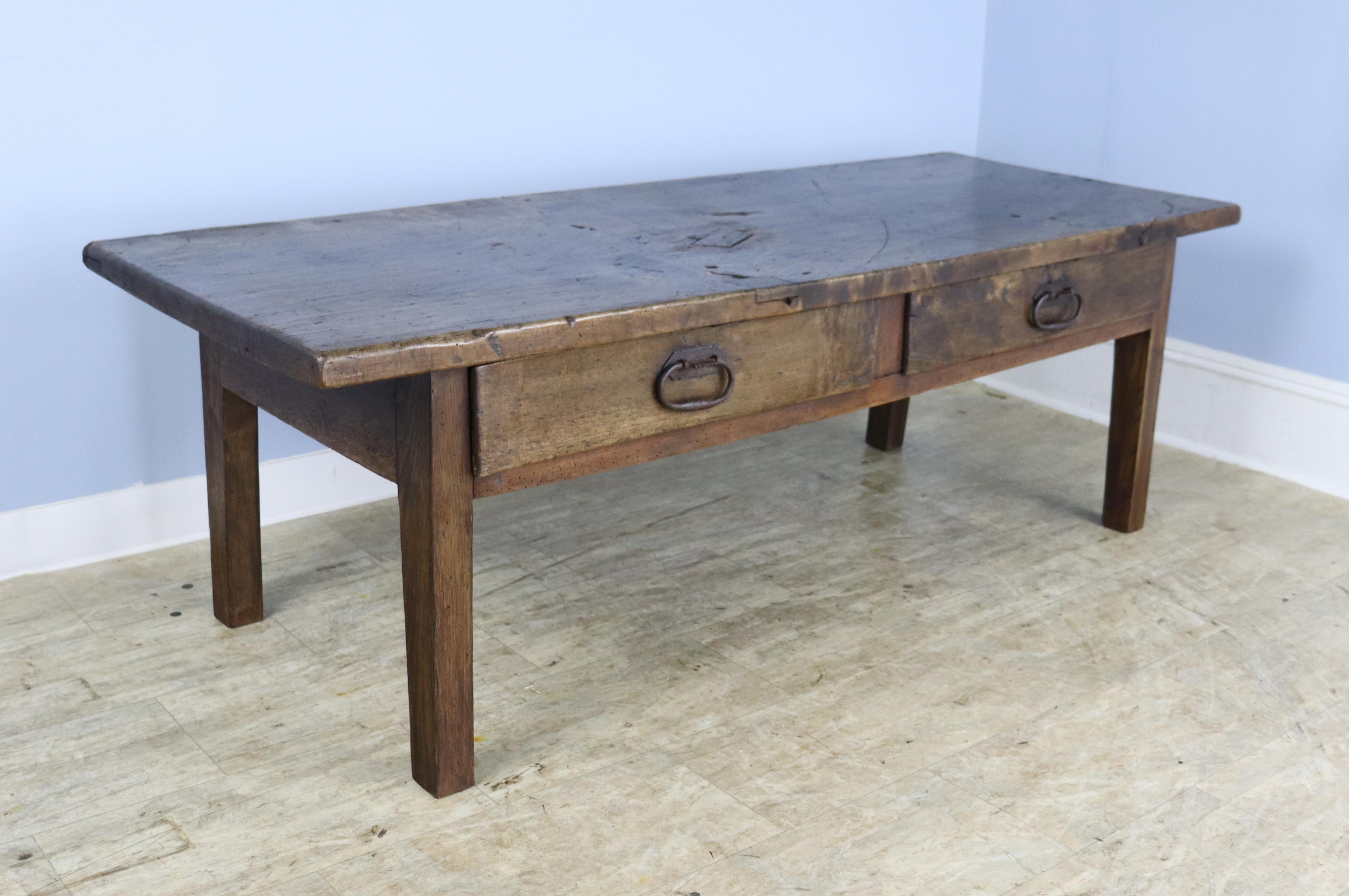 A chunky country Spanish coffee table in well worn polar.  Nice thick top and two roomy drawers with original wrought iron pulls.  Raised panels at the back provide interest from all sides.  Fabulous character and patina.