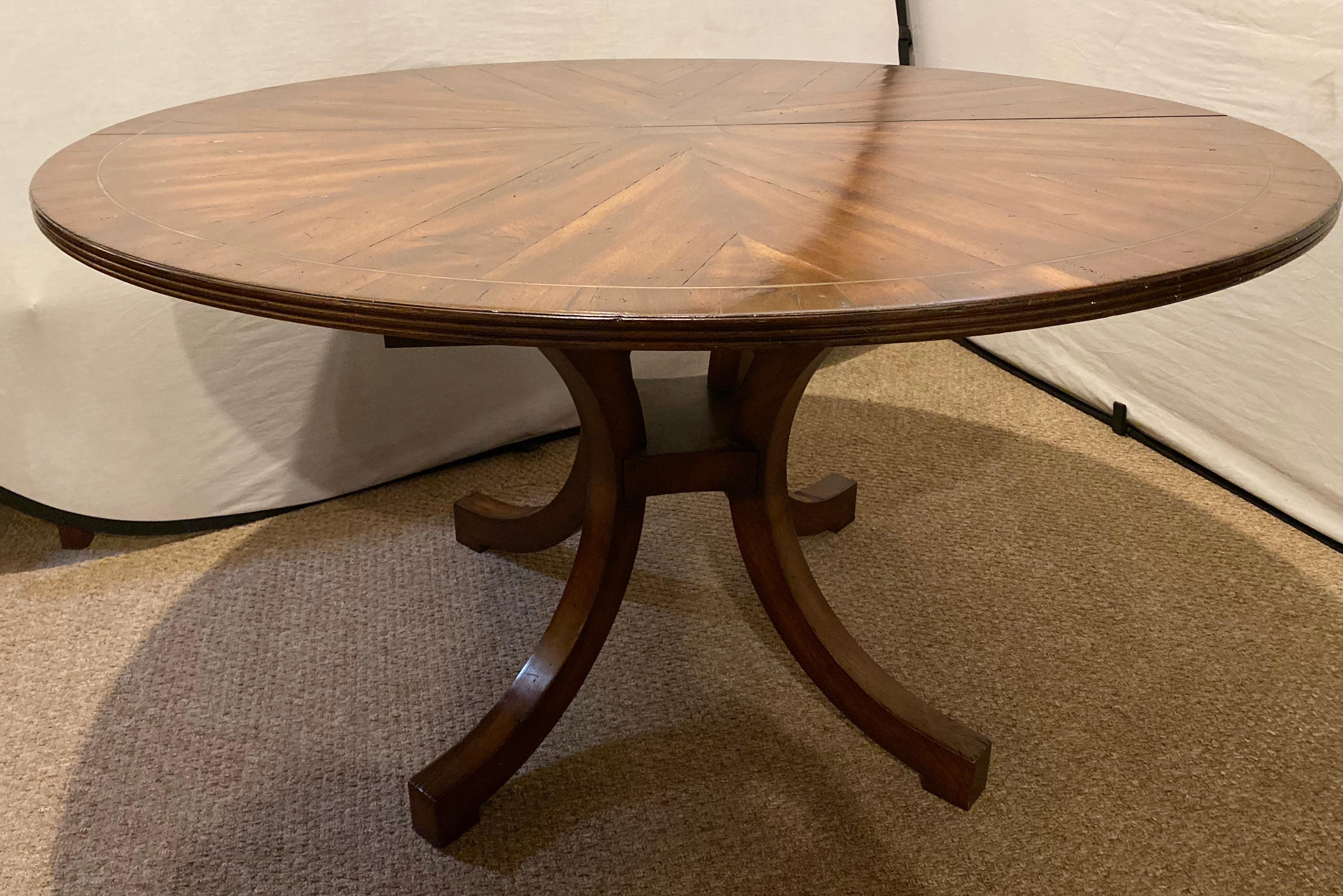Circular boule inlaid dining, center or kitchen table with a rustic finish. Having a single pedestal on four rustic sprayed legs supporting a boule star burst inlaid table top of solid wood with fine grained finish. This custom dining or kitchen