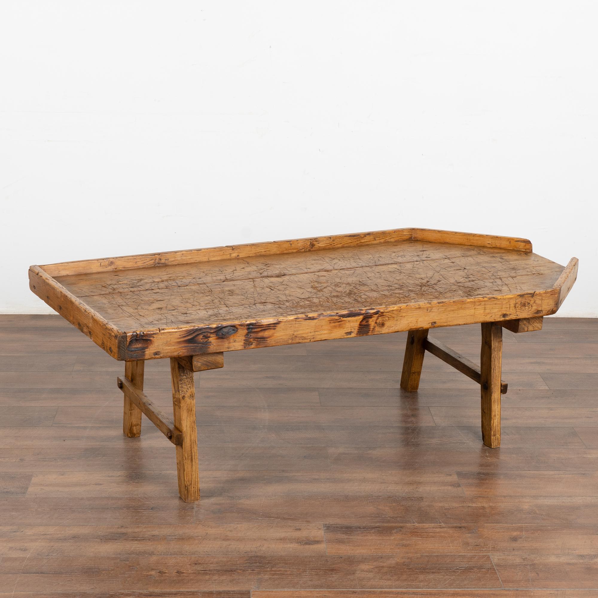 Table basse rustique en pin de ferme d'un peu plus de 5' de long chargée de caractère vintage. 
Cette construction unique, avec son plateau, a servi pendant des années de plateau à fromage, utilisé à l'origine pour faire du fromage. Notez les