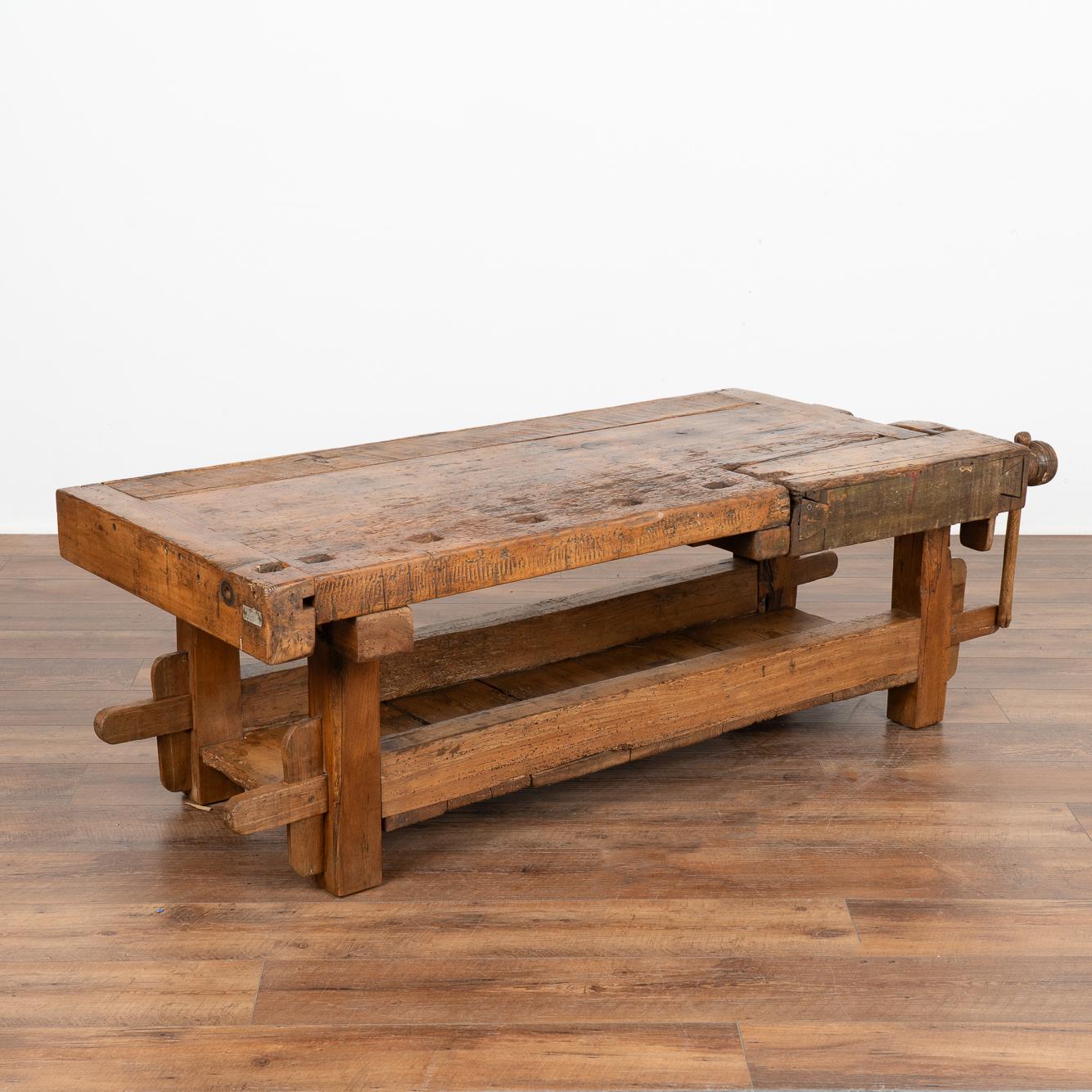 This rustic coffee table is a rare find. It was formed from a large, old carpenter's workbench and scaled down to coffee table height. 
It is the years of constant use revealed in every ding, gouge, old dried worm hole and stain that enrich the