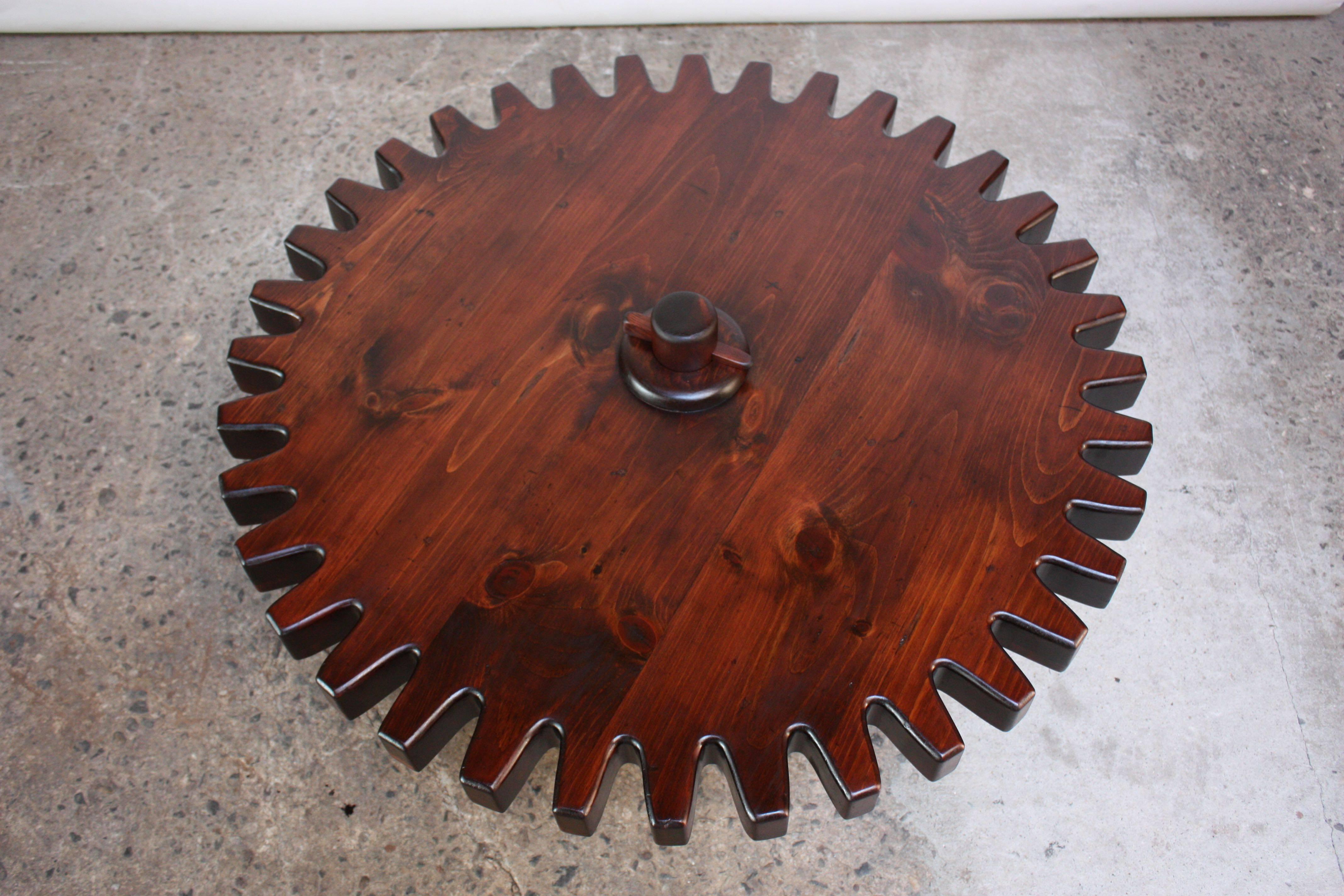 English pine pub / coffee table (late 1960s) fashioned after a gear / cog wheel with a spinning top and dense, circular base. Smooth movement to swiveling top, which spins with ease.
Ethan Allen made a version of this table in 1971 with a square