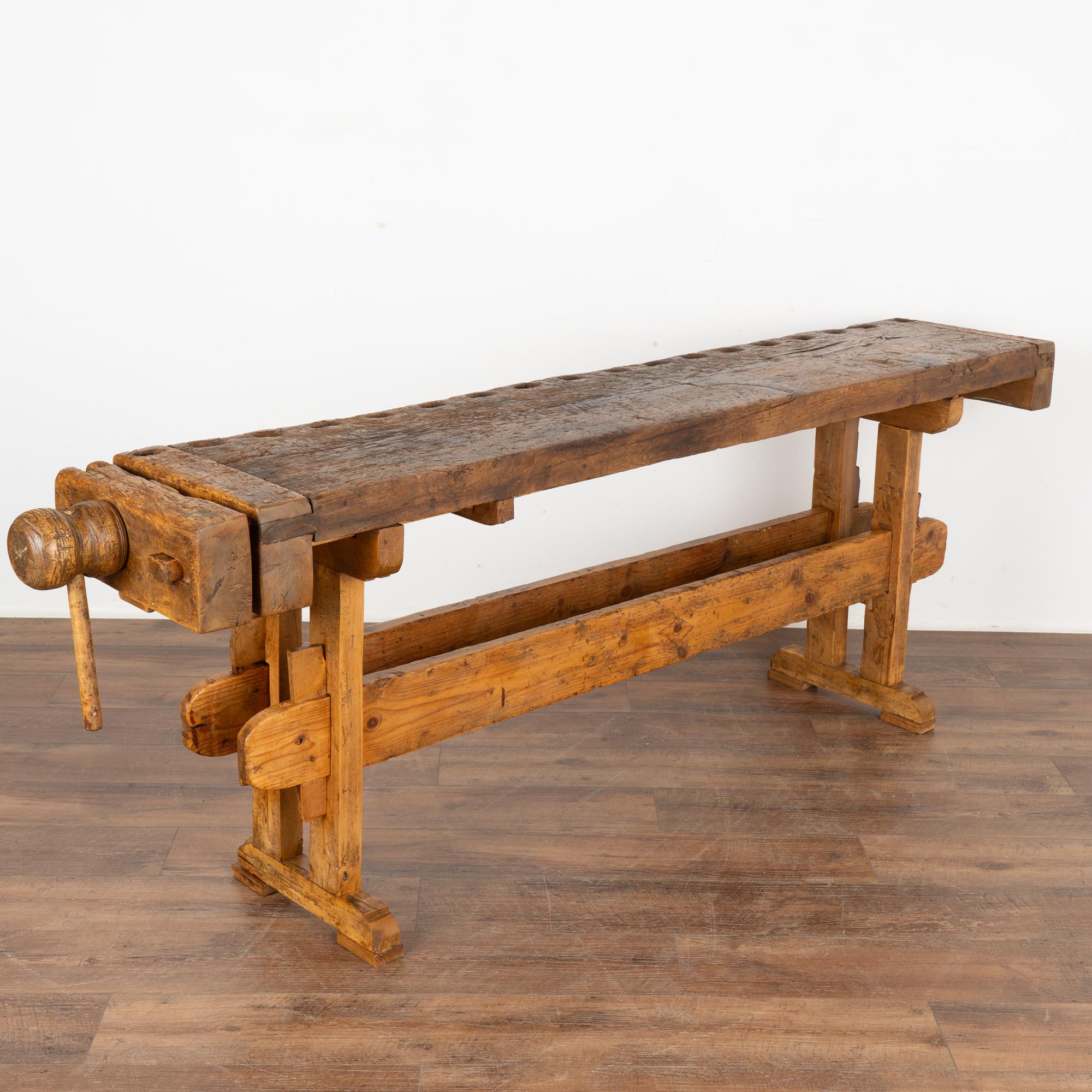 The rich patina of this old carpenter's workbench is a reflection of its age and years of use. Every ding, scratch, crack, deep gouge and stain enrich its character and appeal.
This rustic work table is narrow, at only 15.25