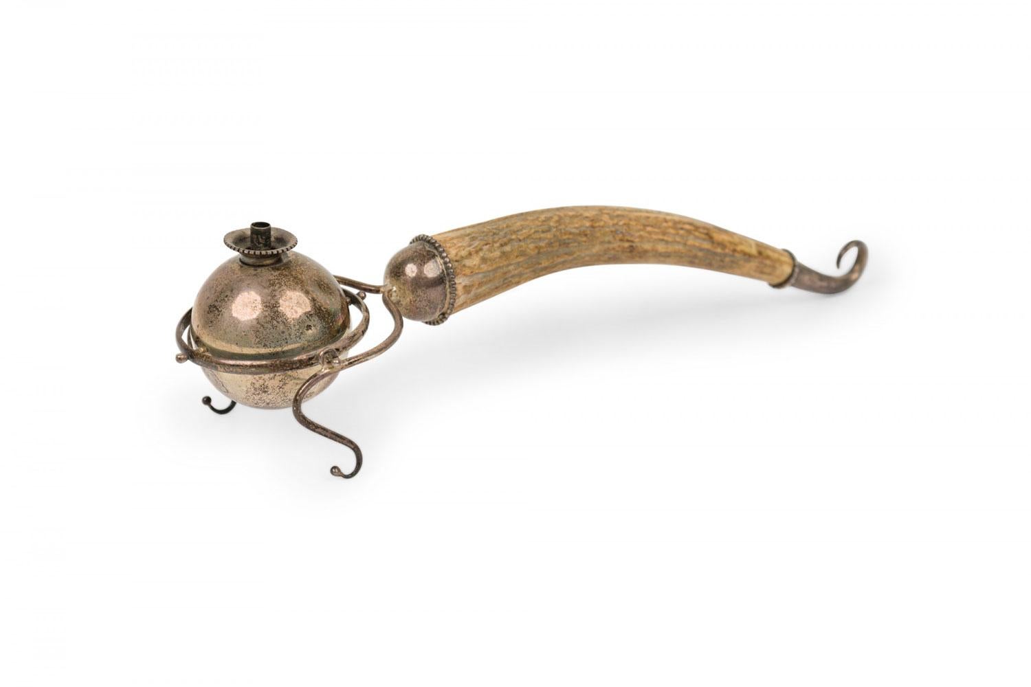 Briquet de bureau rustique de style continental (19/20e siècle) à boule rotative en métal orientée vers la gravité avec un repose-main en métal incurvé, et une poignée en corne se terminant par un capuchon en métal enroulé.