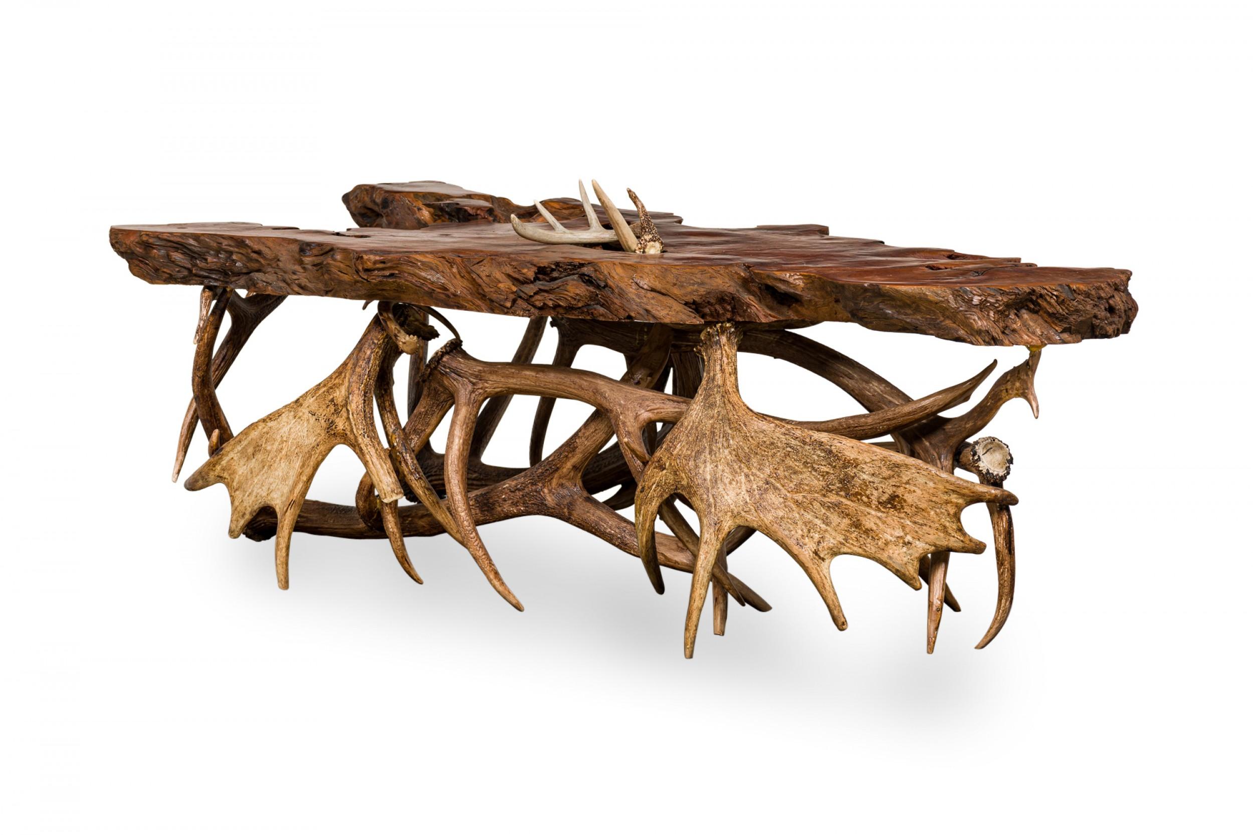 Rustic Continental-style coffee table with a live edge organic wooden slab top resting on a group of cast resin deer and moose antlers.
