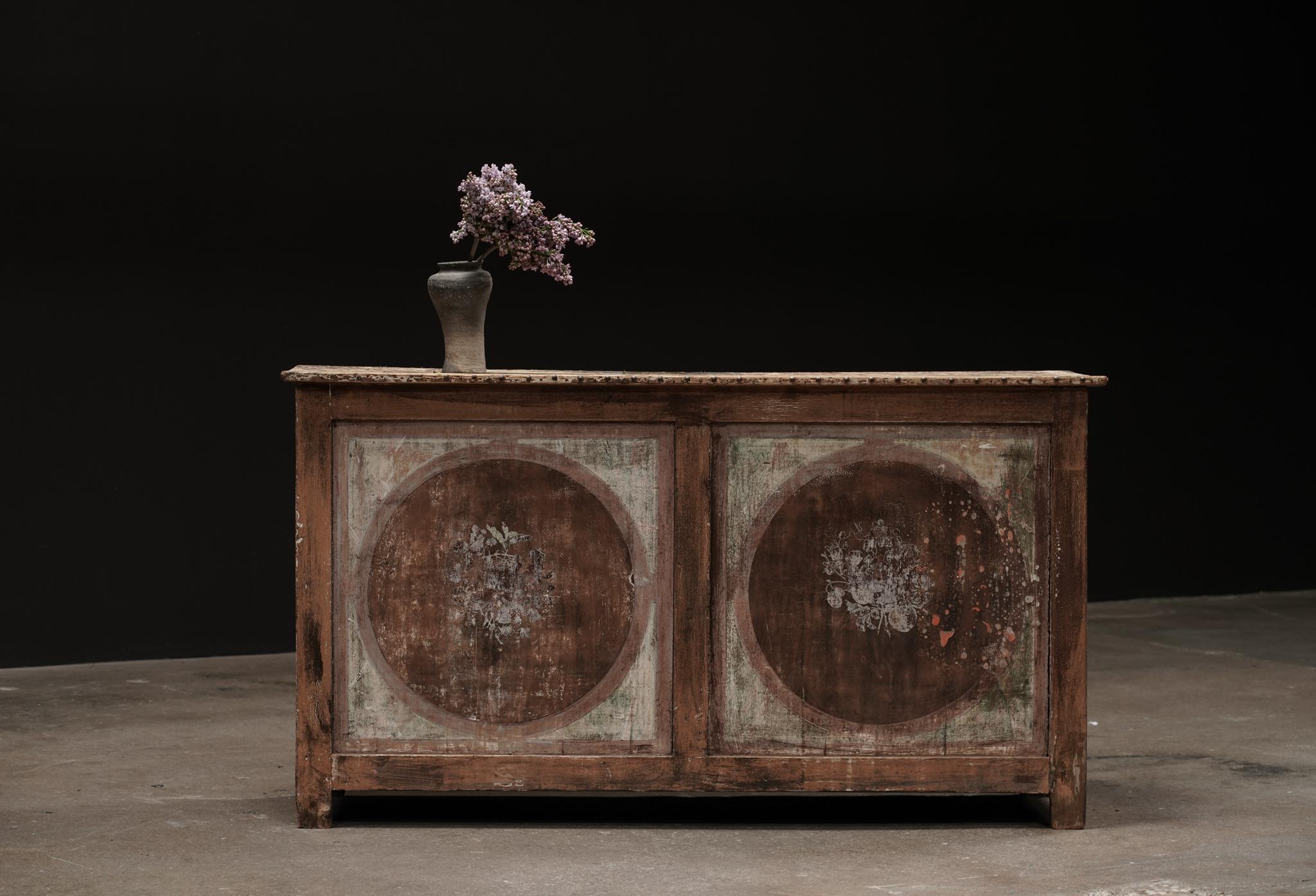 A refined blend of history and charm, this Rustic Painted Motif Counter hails from Europe, circa early 19th century. Its romantic patina and hand-painted detailing speak to years of craftsmanship and character, making it an enduring statement piece