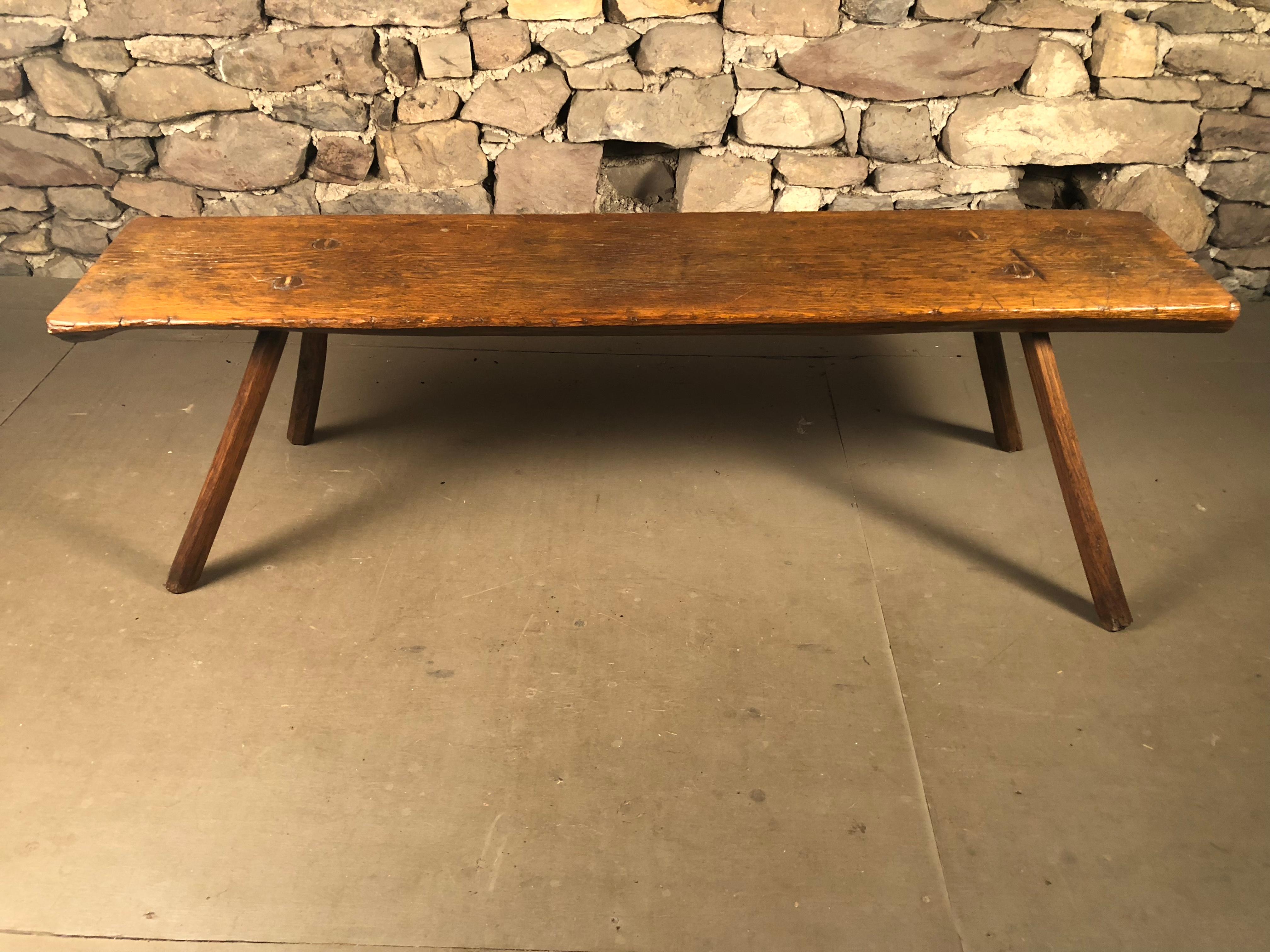 A rustic country slab bench with splayed legs, American circa 1850 in oak. 
 