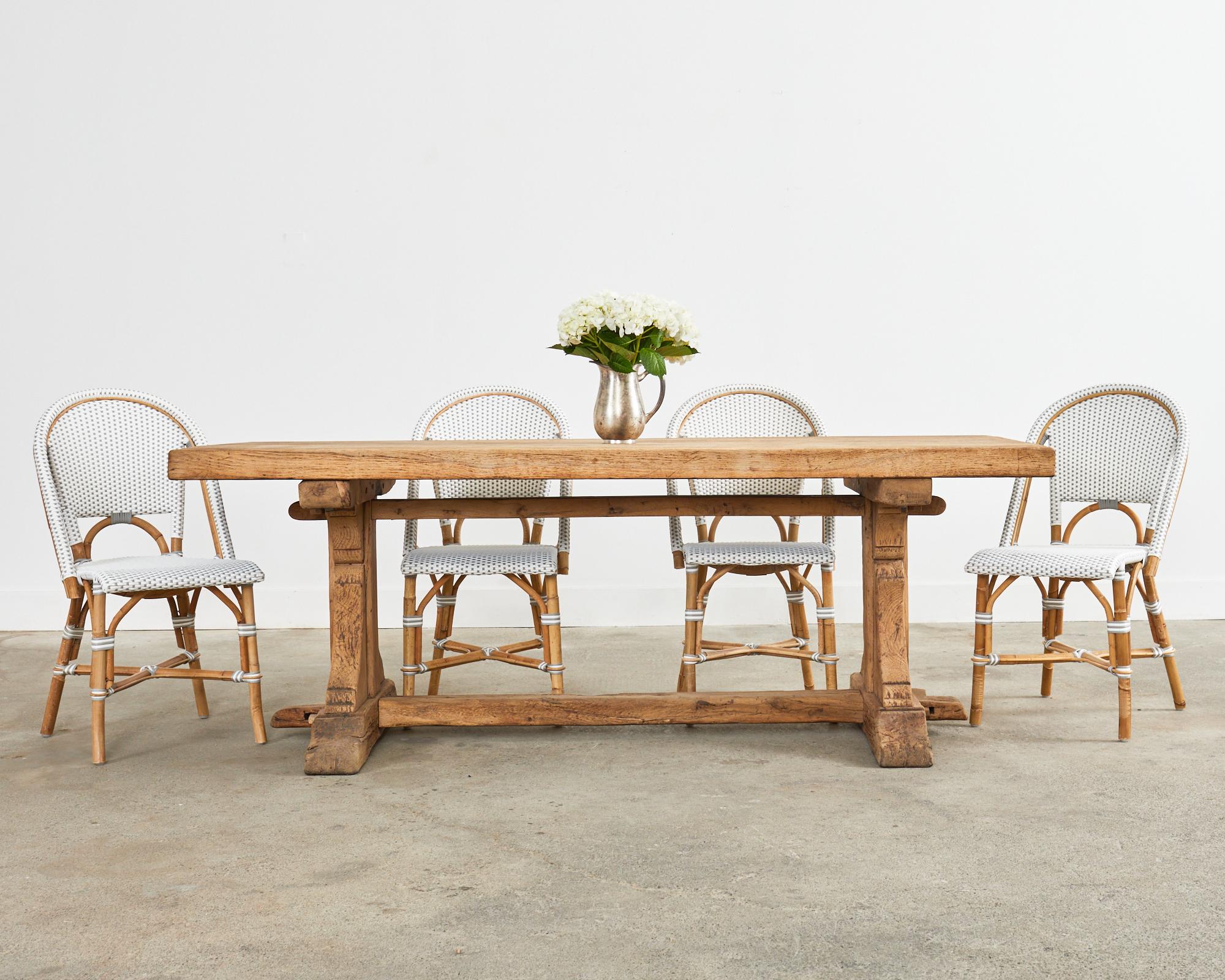 One of our absolute favorites is this country French farmhouse dining table featuring a bleached oak finish. Very heavy and solid with rough-hewn weathered patina on the trestle base. The rustic table has an oak slab top measuring nearly 3 inches