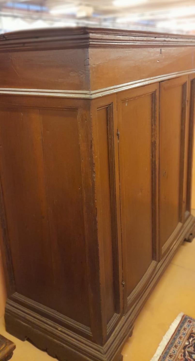 Rustic credenza from the 1600's, in walnut with opening door on the top.

The butterfly hinges and locks are original.
The beautiful walnut wood has only been waxed. 
Never restored, healthy and well preserved structure
From Italy.

Measures: W. cm