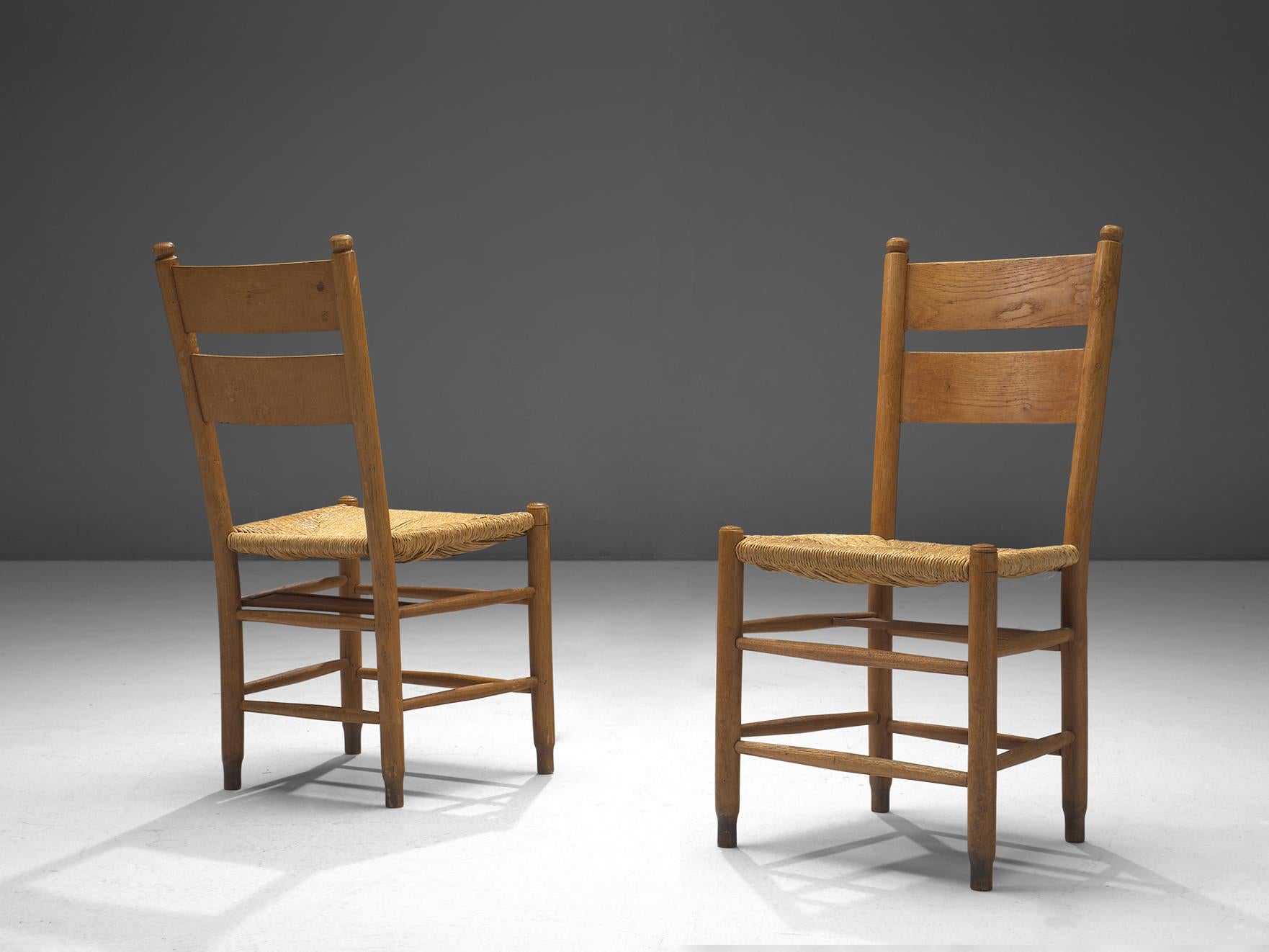 Sedie da pranzo, Oak, vimini impagliato, Danimarca, anni '60 

Una coppia di rustiche sedie da chiesa danesi, costruite in resistente legno di quercia e caratterizzate dalla caratteristica seduta in paglia. In particolare, queste sedie vantano