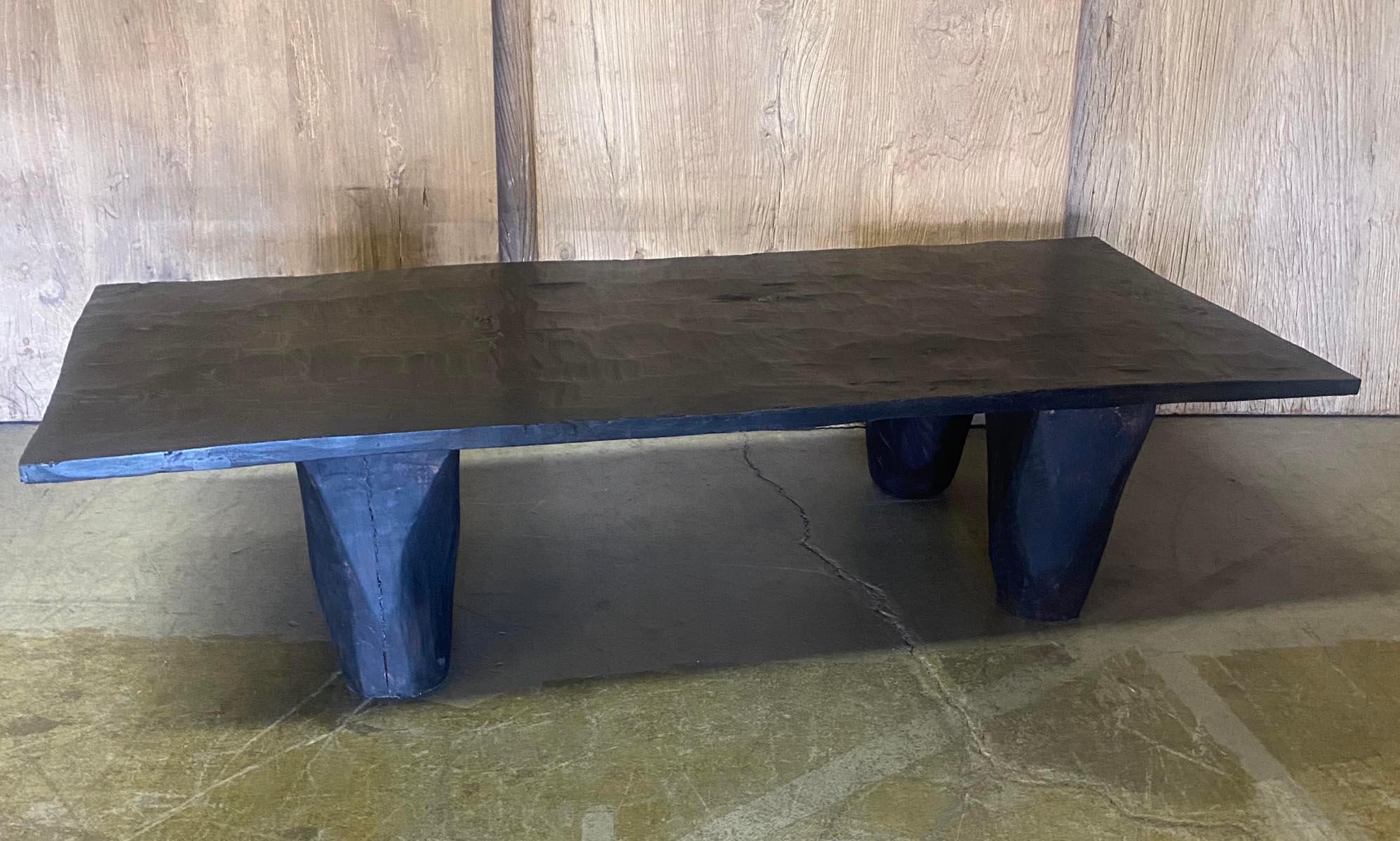 This coffee table is made from one an antique wide board top and reclaimed wood legs, carved in a conical shape. Dark patina, wax finish. Striking
