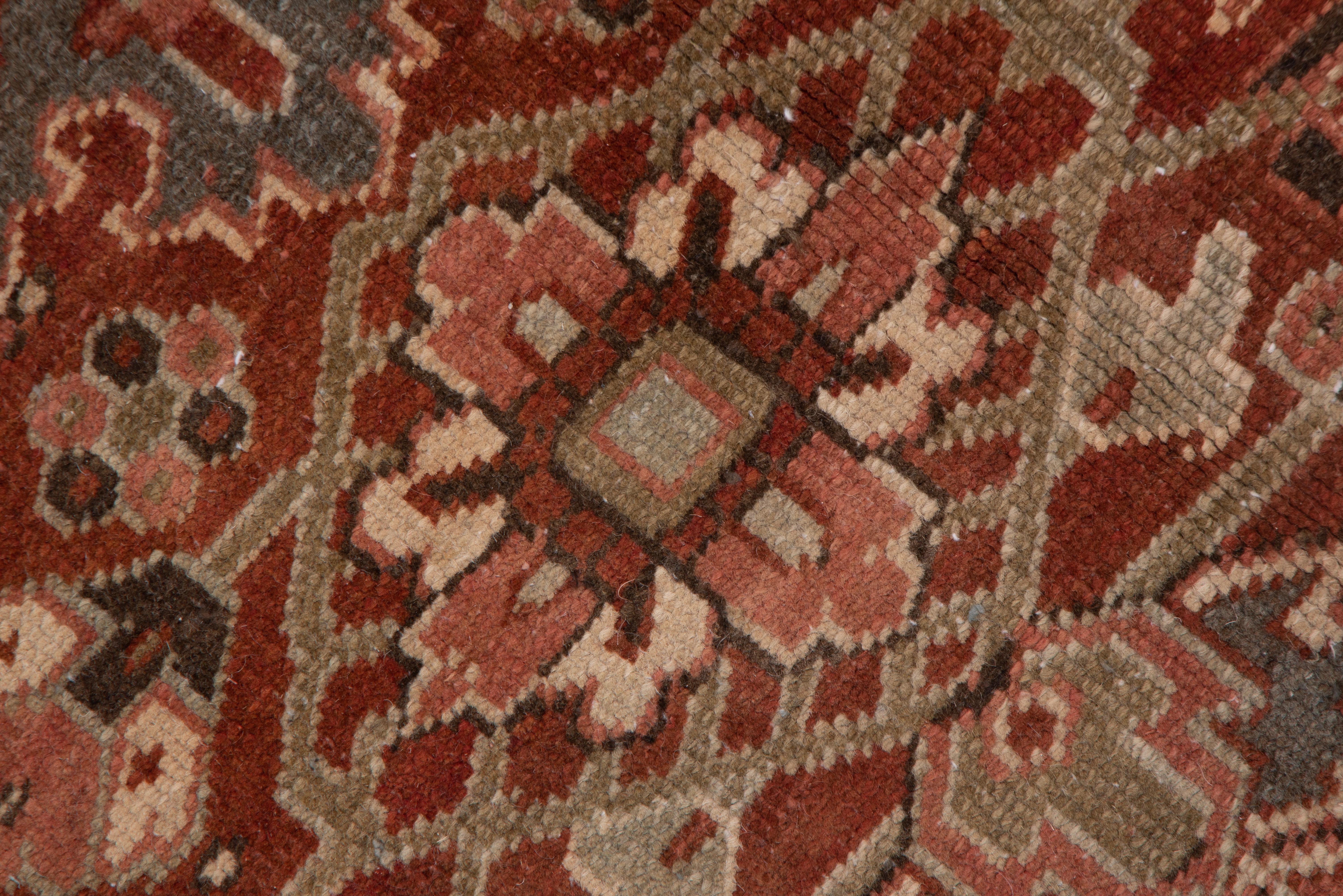 This dark toned NW Persian village carpet presents a well-abrashed green main border with large reversing turtle palmettes which frames the characteristic brownish-red field with a large central cream octogramme medallion and surrounding angular