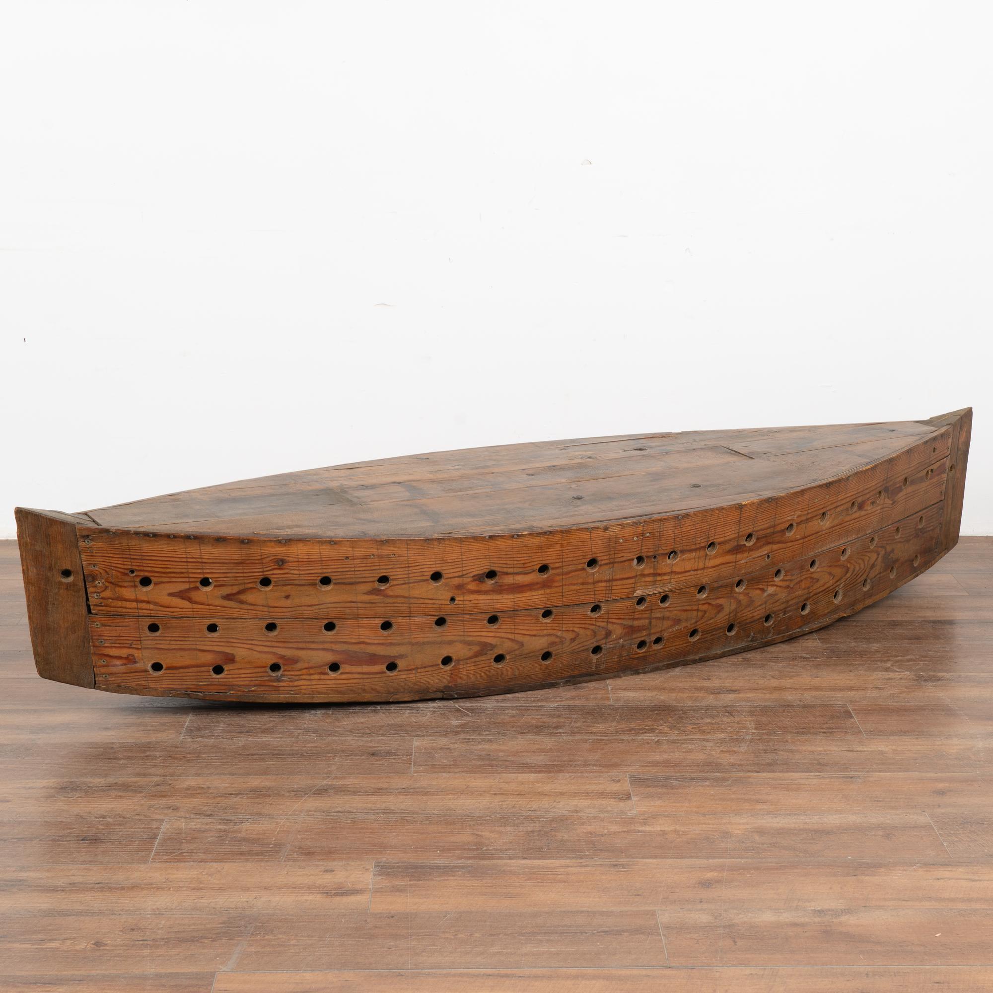 The many holes in this large 7' model boat served a specific purpose; it was used while fishing as a type of oversized creel to keep fish alive. The large size makes it a unique decorative statement piece perfect for a home near water.
Note the