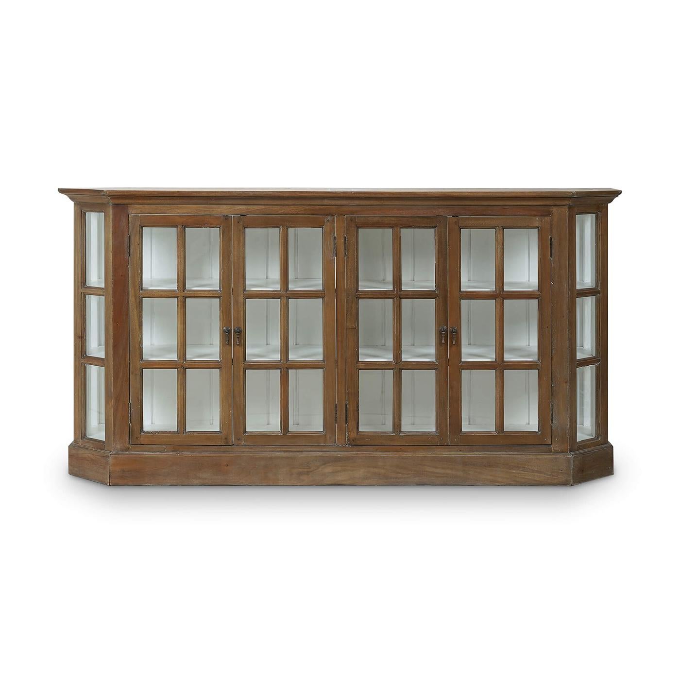 Featuring a lightly distressed straw wash finish and a white-painted interior. Crafted from solid mahogany, this cabinet exudes rustic elegance with its natural finish that beautifully highlights the wood's character. The canted corners and framed