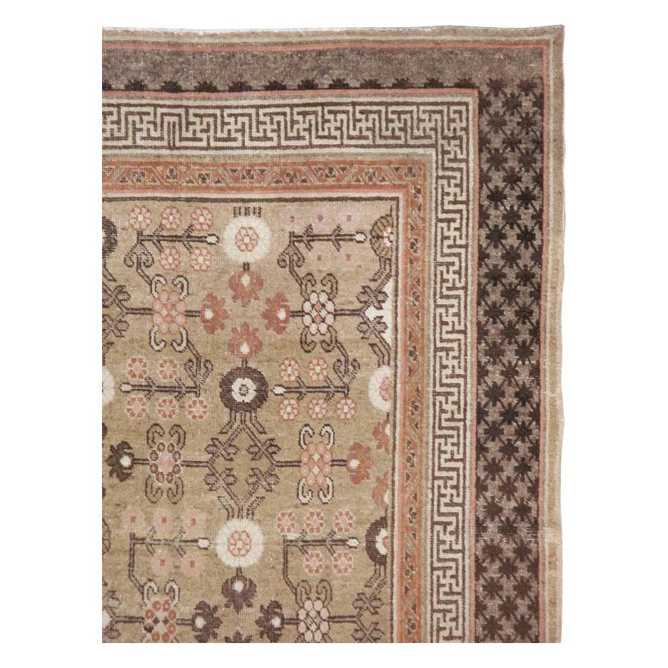 An antique East Turkestan Khotan accent rug in gallery format handmade during the early 20th century with a rustic and geometric design in brown and cream tones, and rust accents.

Measures: 5' 2
