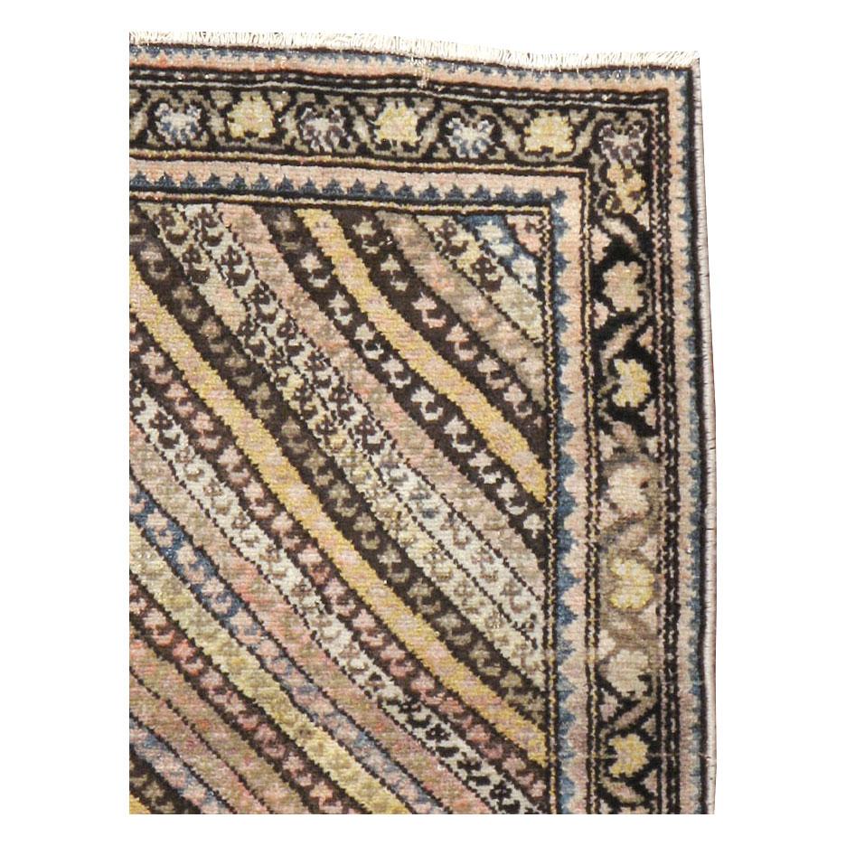 An antique Persian Malayer throw rug handmade during the early 20th century with a multicolored design of diagonally striped bands filled with tiny rustic 'botehs (paisleys)'.

Measures: 3' 6