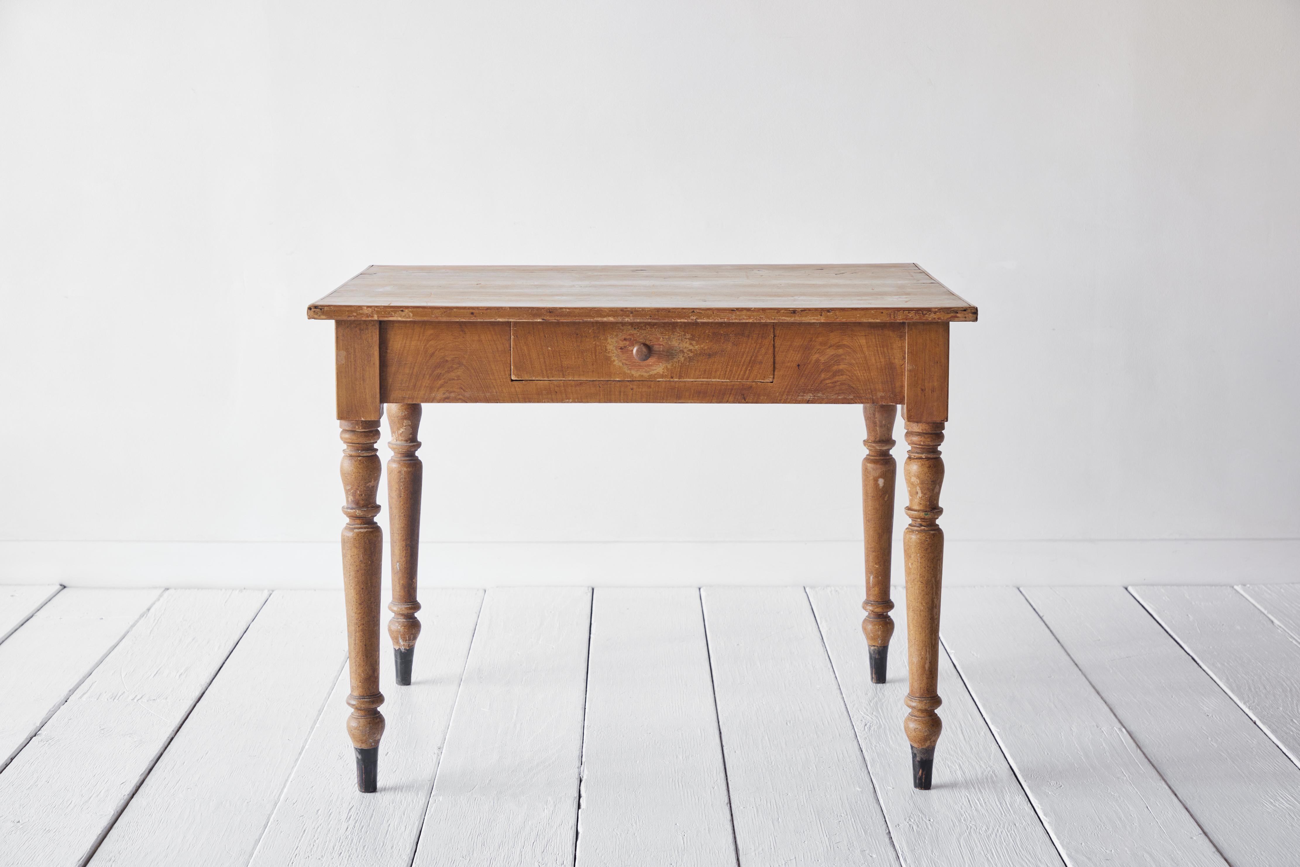 Rustic early American table turned leg table with a single drawer. The grain on the table offers rustic charm and patina.