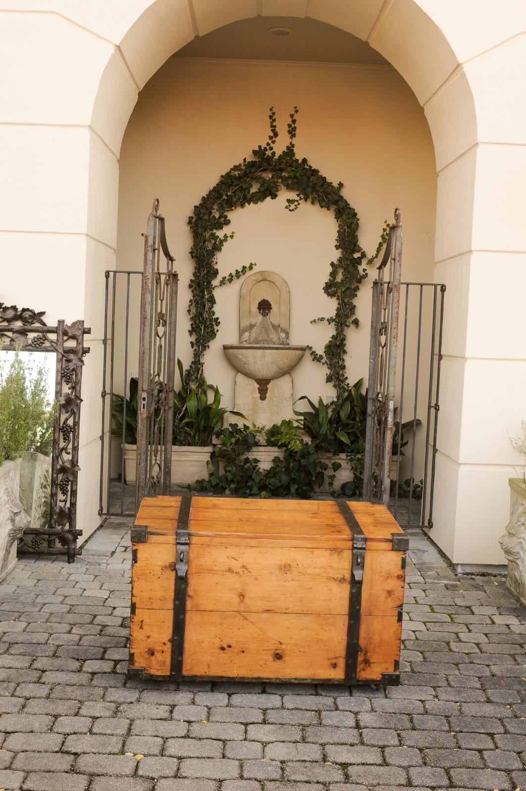 An English rustic Georgian period pine trunk from the early 19th century, with tin-lined interior, casters, iron straps and handles. Born in England during the first quarter of the 19th century, this rustic pine trunk presents a clean, linear