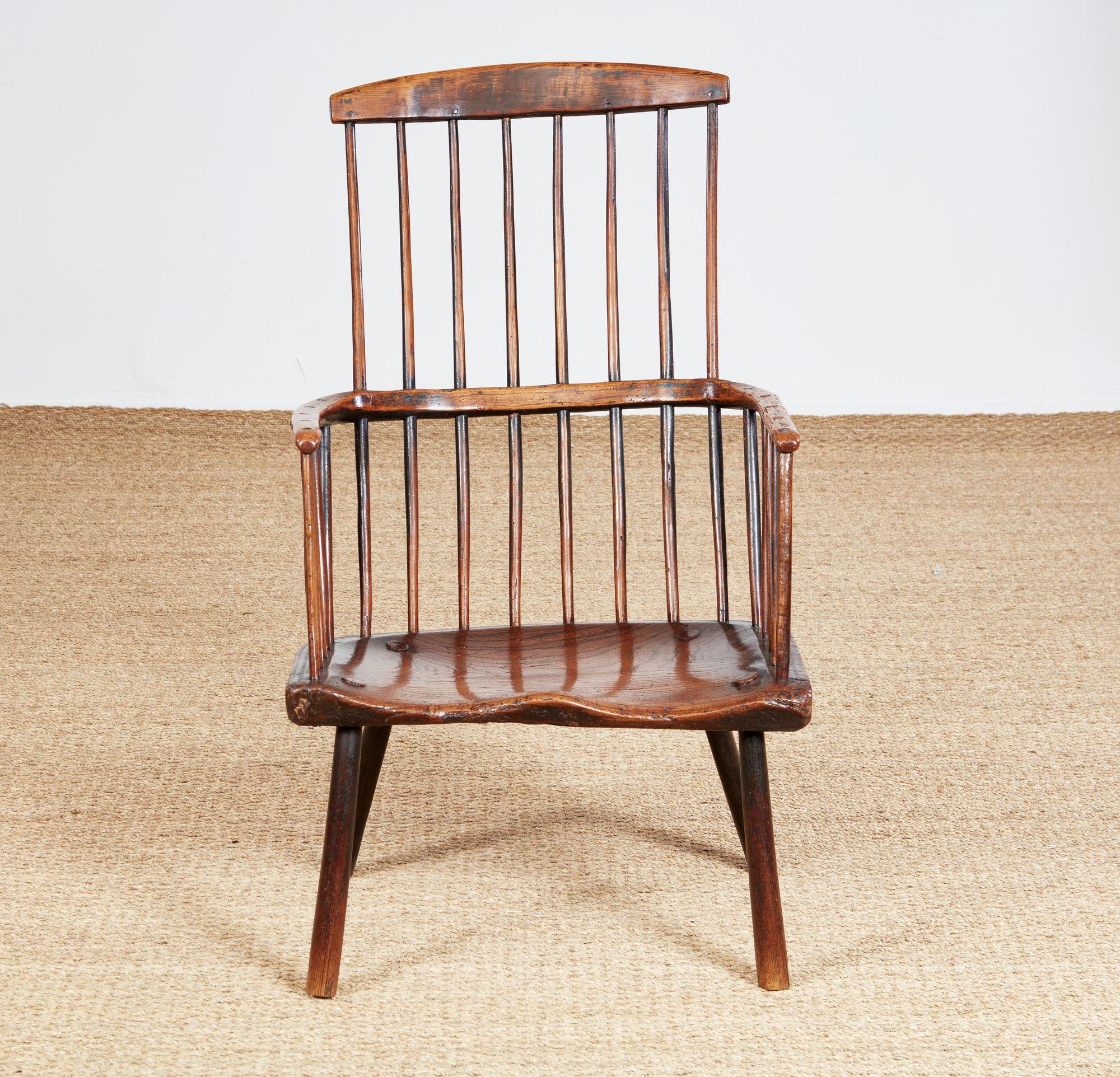 Charming 18th Century English country comb back Windsor armchair, the arched crest rail over eight tall spindles, the continuous arm supported by a further eight short spindles and two spokeshaved arm supports over deeply saddled elm seat, over