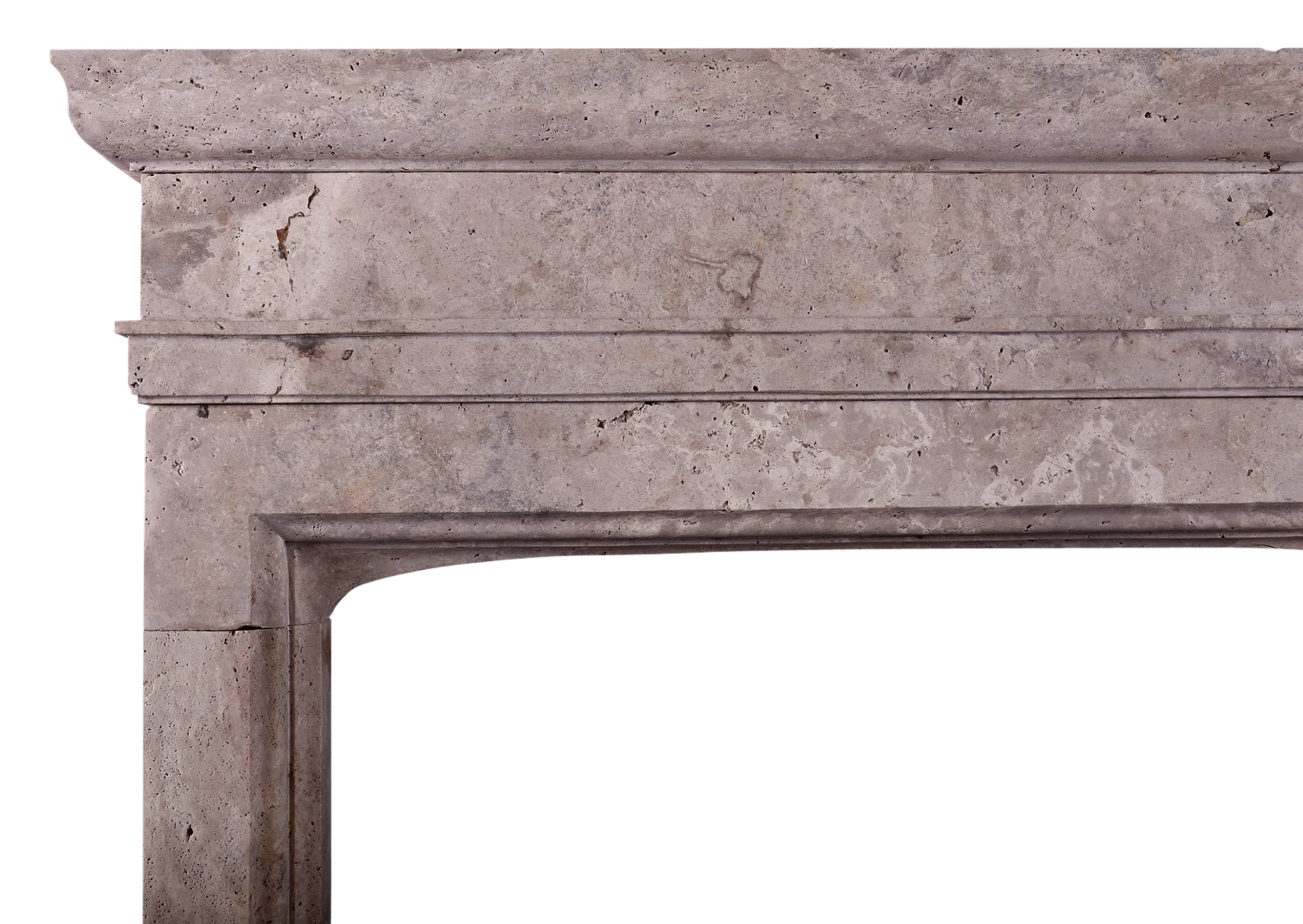 A large stone fireplace in the Gothic style. The moulded jambs with plain frieze above and heavy moulded shelf. Rustic travertine stone. English, modern.

N.B. May be subject to an extended lead time.

Shelf Width:	1620 mm      	63 3/4 in
Overall