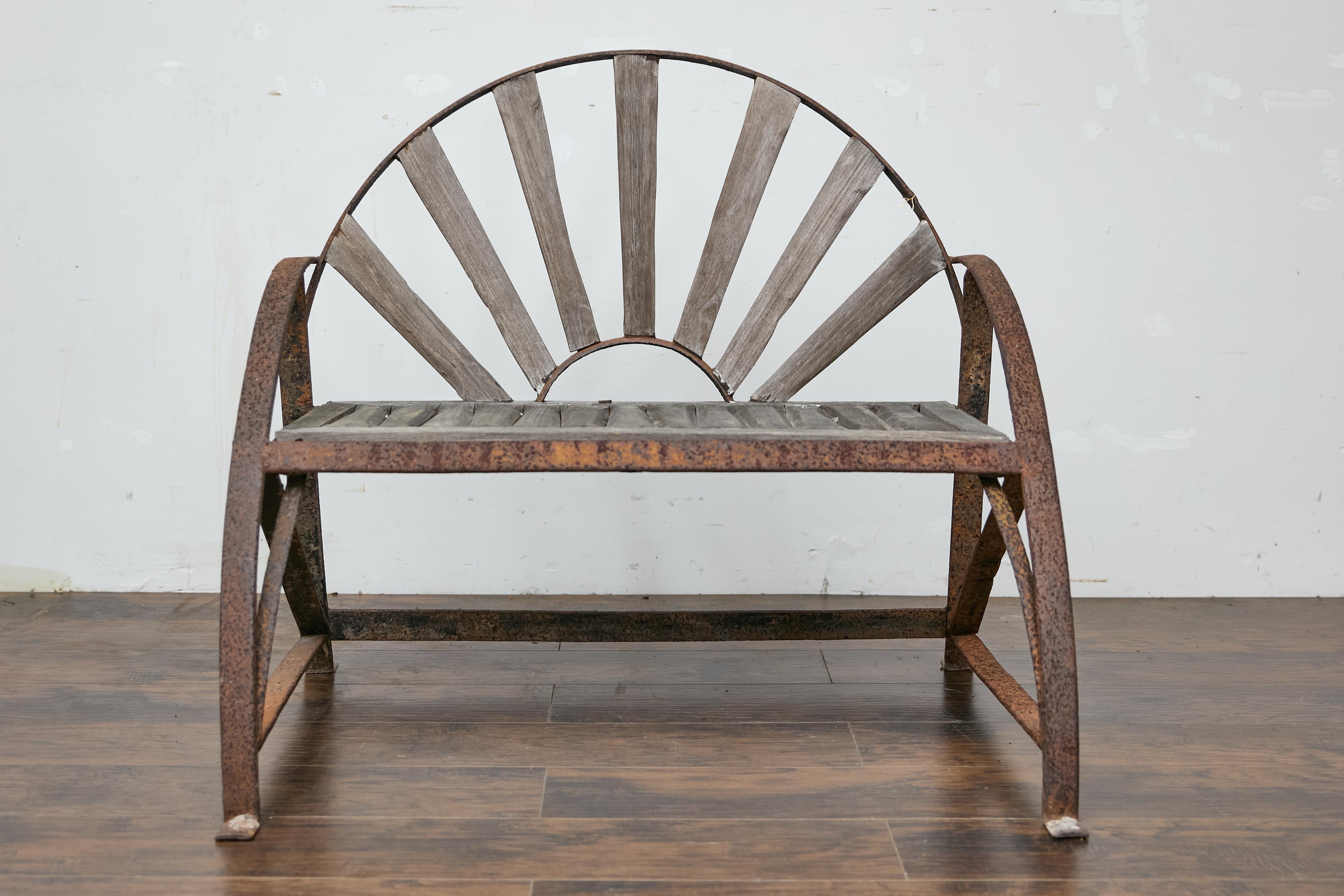 Banc de jardin rustique en fer de l'époque victorienne anglaise du XIXe siècle, avec dossier en forme d'éventail, assise en bois et patine rouillée. Ce charmant banc de jardin en fer d'époque victorienne anglaise du XIXe siècle capture l'essence de