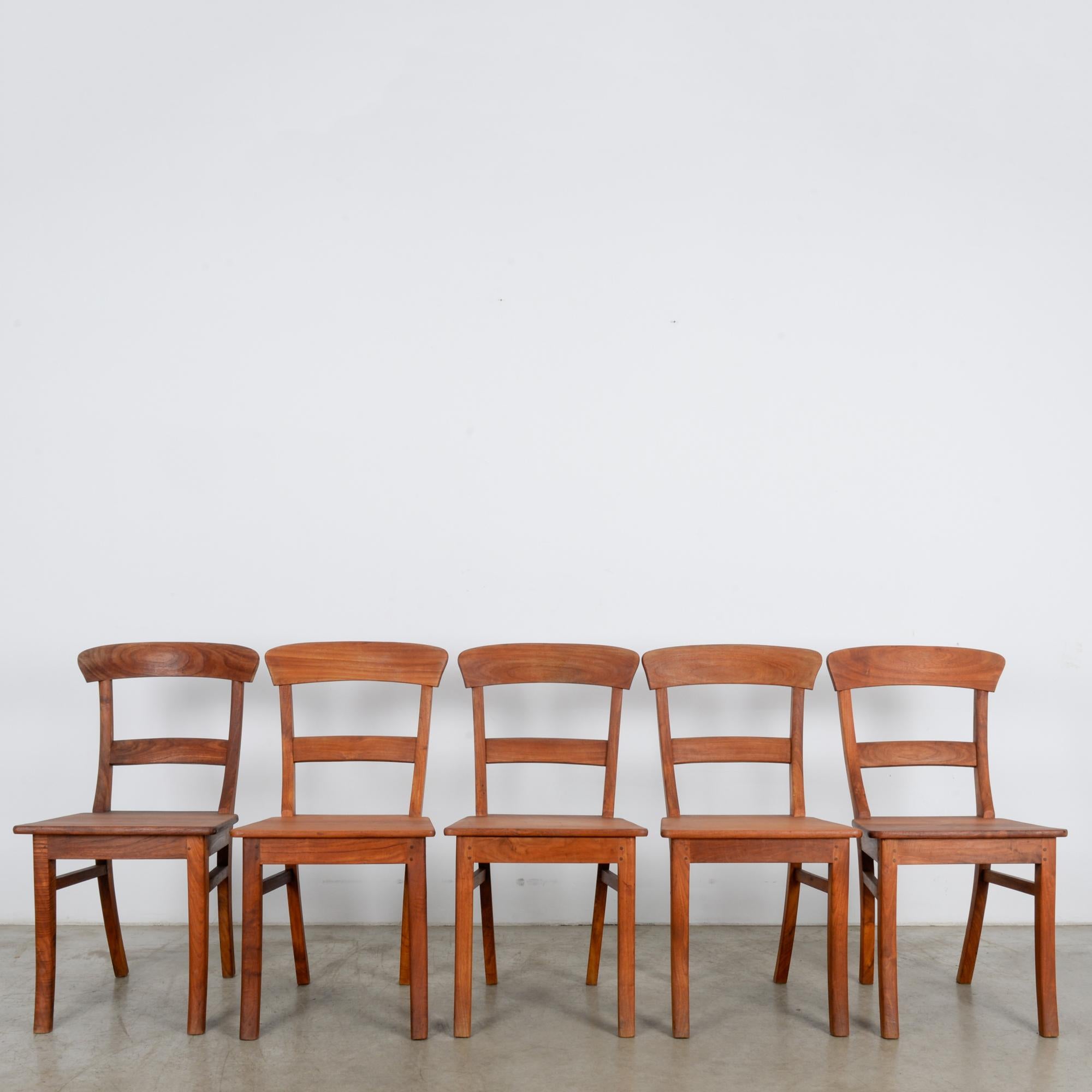 A distinctive set of five European dining chairs. Visible from the side are the distinctive arcs of the splayed legs and back, which will bring style and elegance to your interior space. A gentle lean supports a relaxed posture, while the smooth and