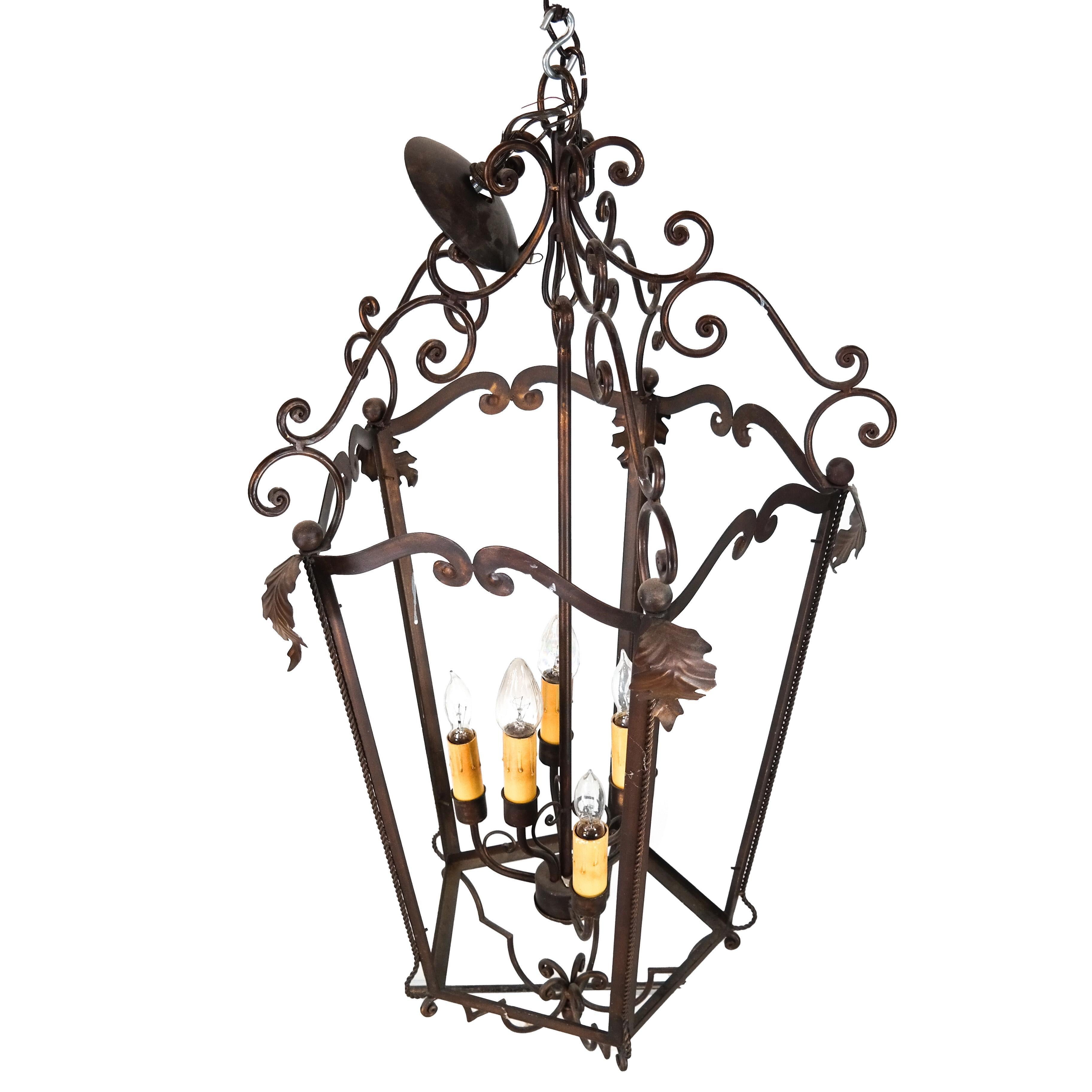 Rustic European style large hanging lantern with leaf motif and curved scrollwork detail.