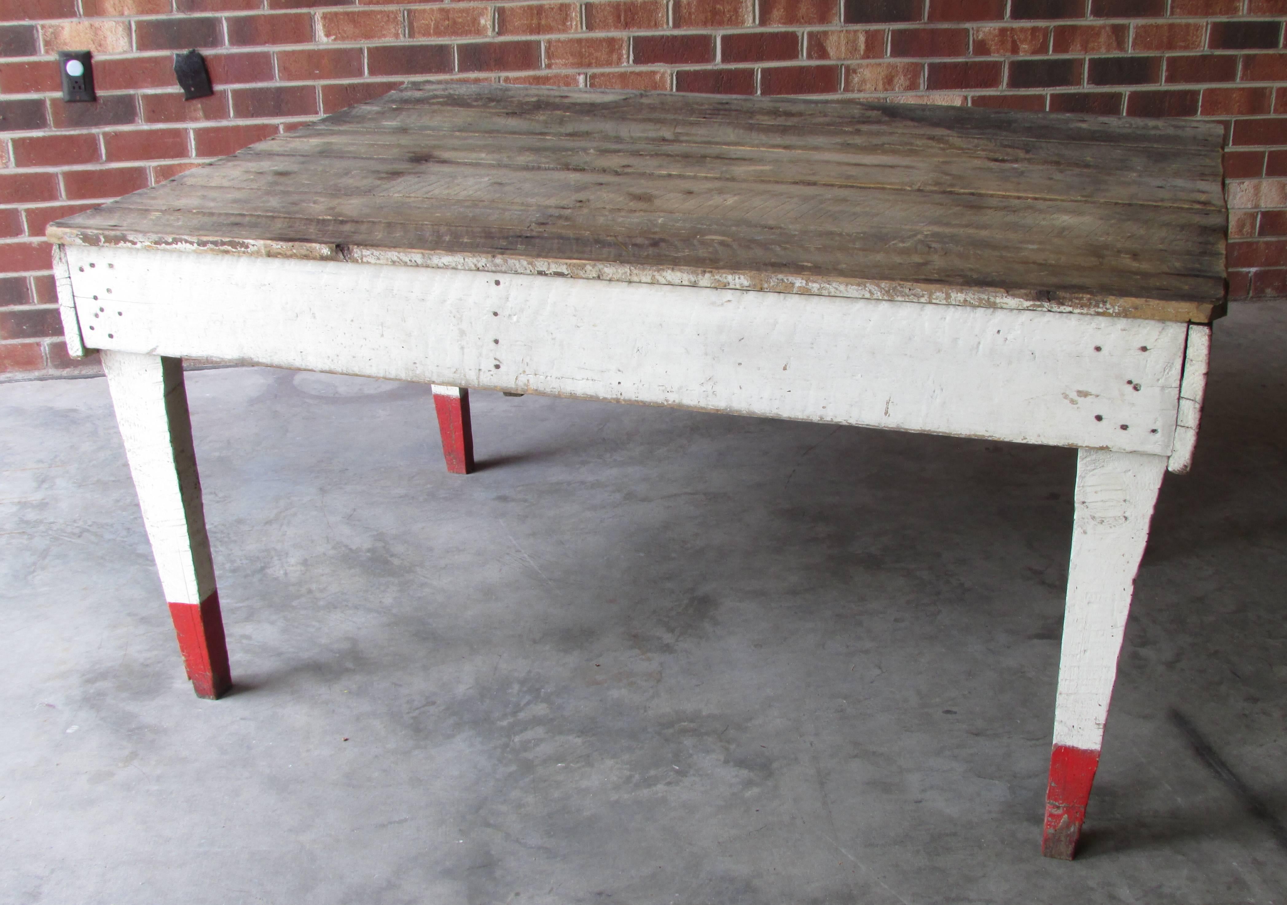 Rustic country farm table with rough sawn top and white painted sides and legs with red tips from Appalachian Mountains.
