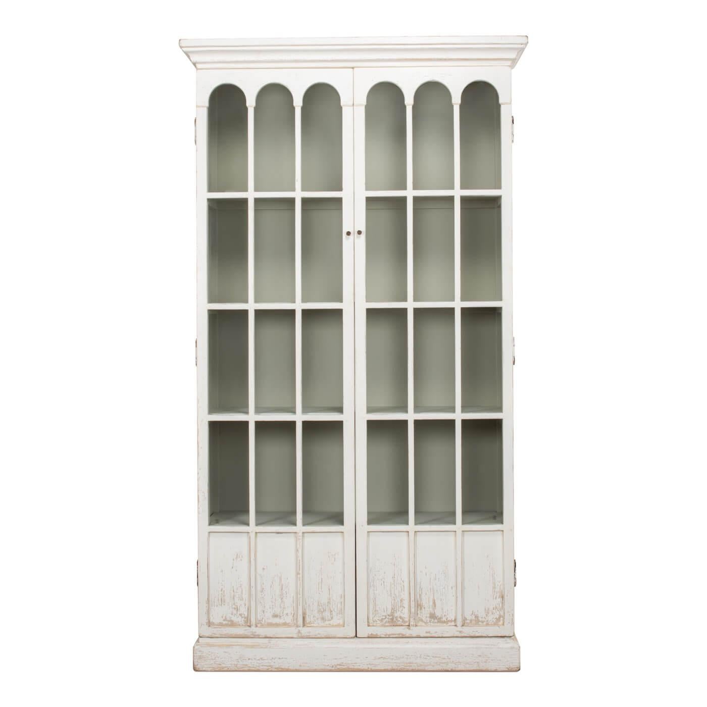 Rustic farmhouse style whitewashed bookcase with decorative glass doors. A beautiful and functional book or display case. This piece has two doors with gothic era-inspired arched glass panels. This case has four adjustable shelves. 

Made of
