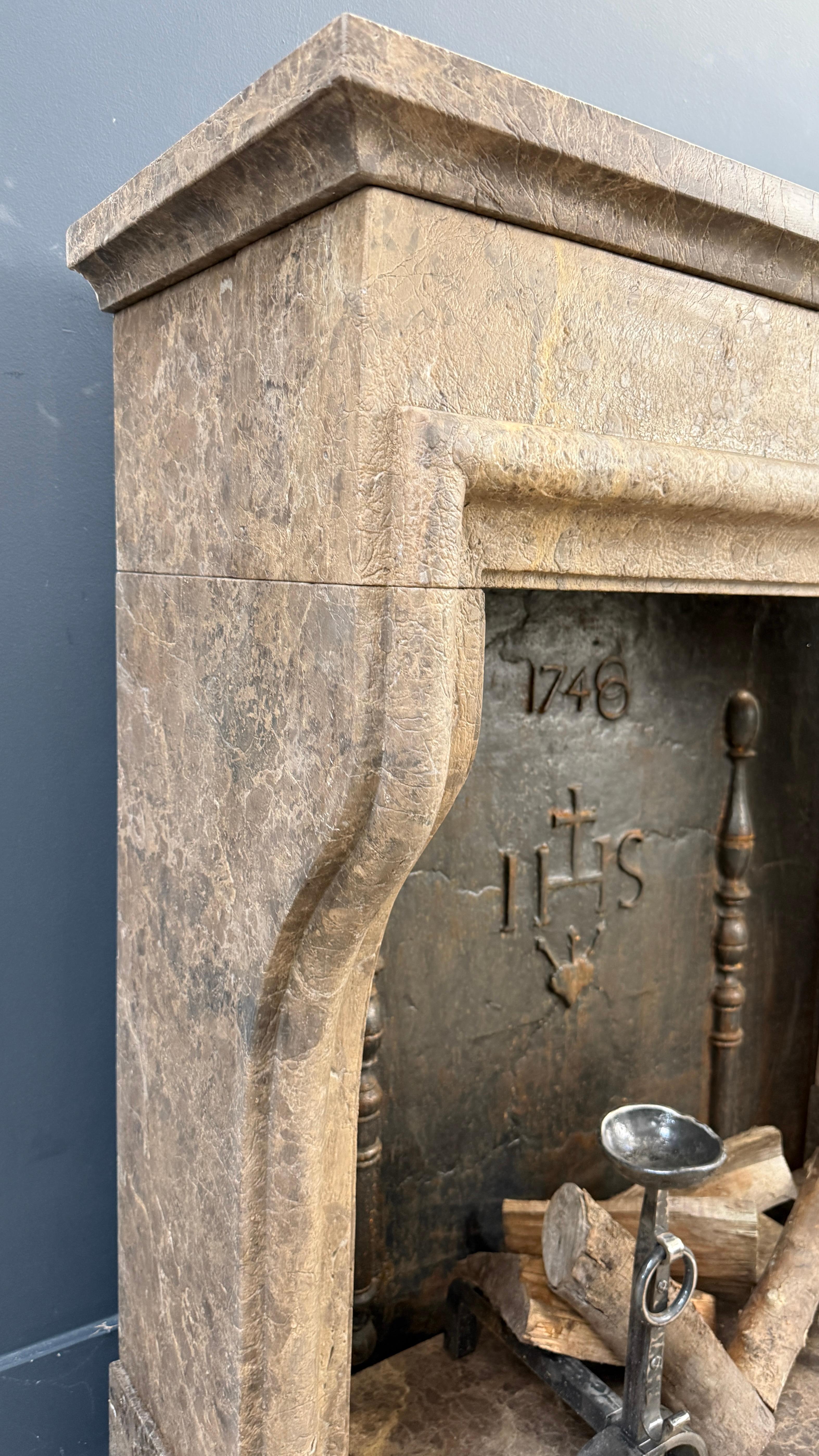 This distinctive fireplace is crafted from natural stone that has been carefully treated to achieve a warm, leather-like appearance, giving the piece an immediate sense of refined calm reminiscent of authentic rustic French interiors.

The gently