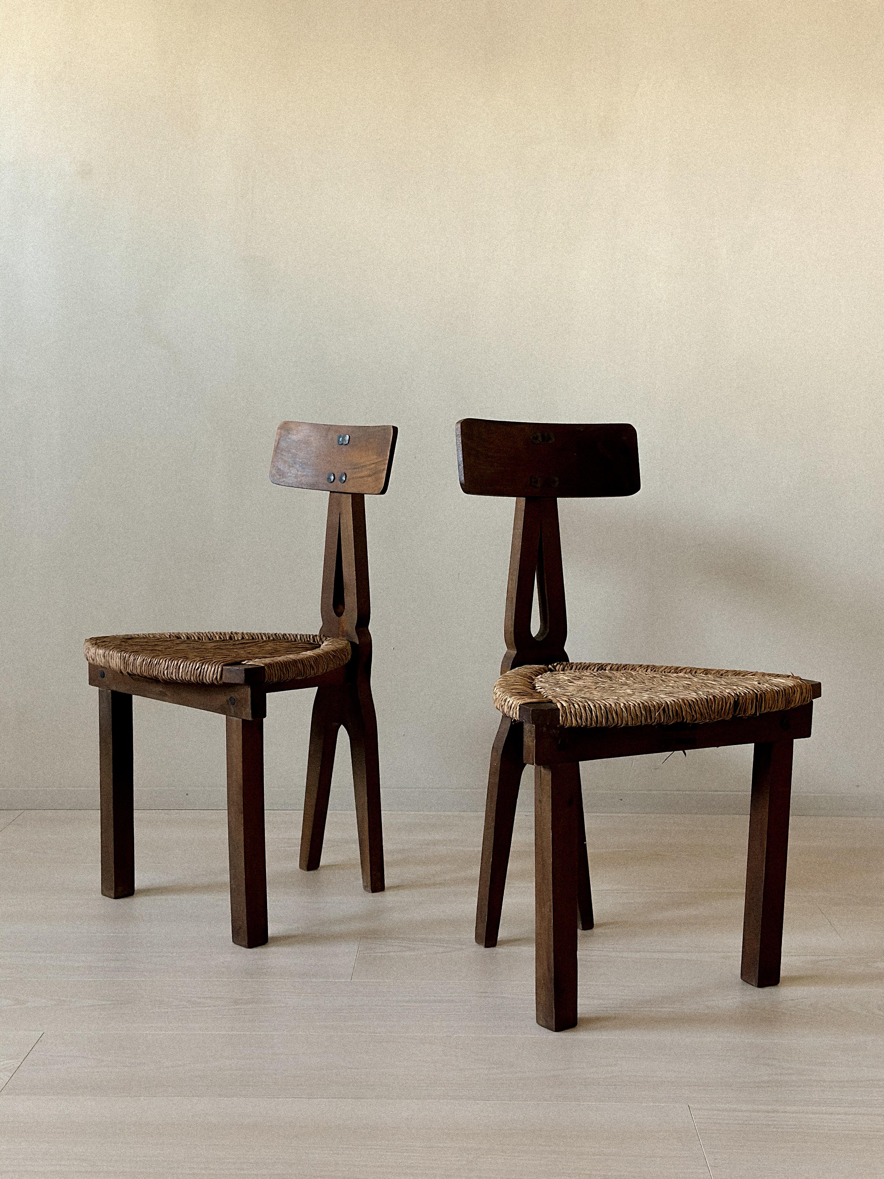Pair of low chairs with sculpted wooden backrests and handwoven rush seats. Designer unknown, Spain, c. 1960s. Wear on rush, backrest panel slightly loose, but stable and fully functional. Wear consistent with age and use.








