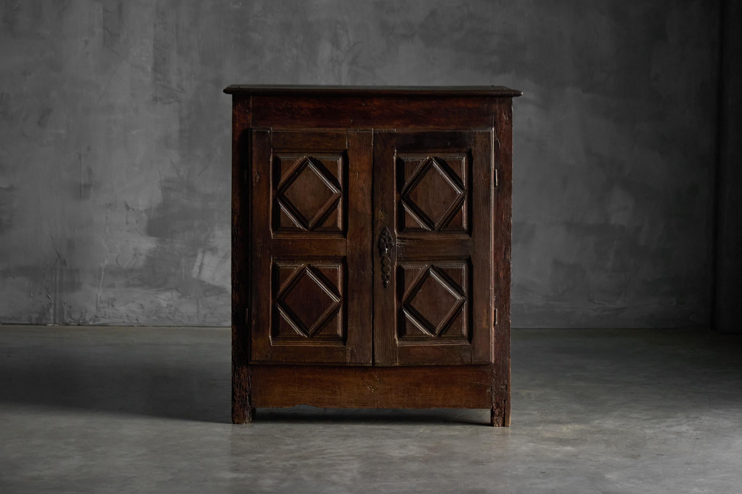 Ce buffet auvergnat du XVIIIe siècle est un exemple frappant de l'artisanat rural français. Sculptée dans du bois massif, elle présente des panneaux géométriques en relief, typiques du style artisanal traditionnel du Cantal. Sa patine riche et