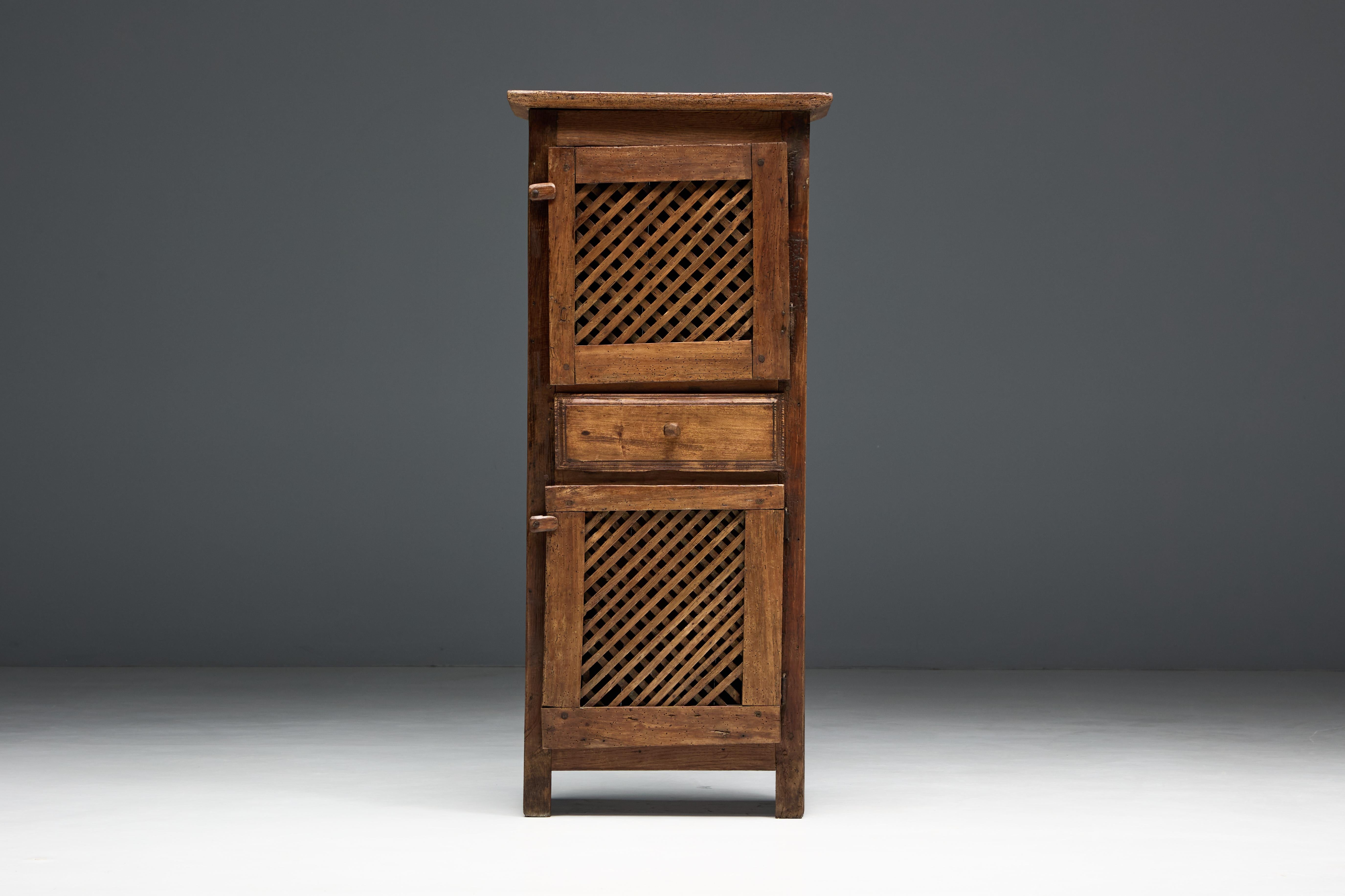 Dieser charmante französische Schrank aus dem 19. Jahrhundert spiegelt die alpine Handwerkskunst im Südosten Frankreichs wider. Er ist aus massivem Lärchenholz gefertigt und zeichnet sich durch eine hohe, schmale Silhouette mit zwei aufwändig