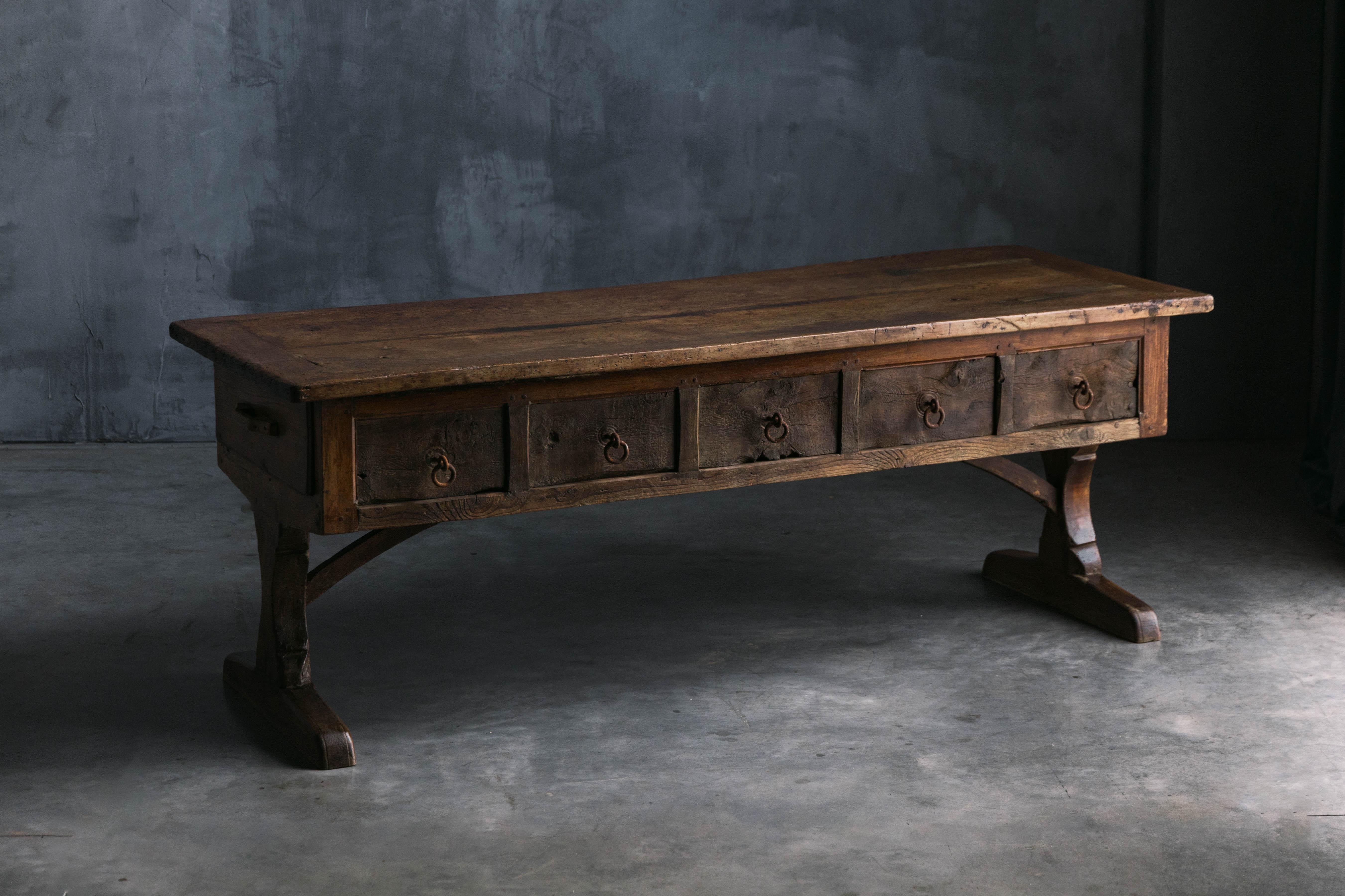 This antique console table, from the 18th century, showcases traditional craftsmanship, originating from rural France. It features five drawers across the front, providing ample storage, while the back has a single central drawer. Its robust wooden