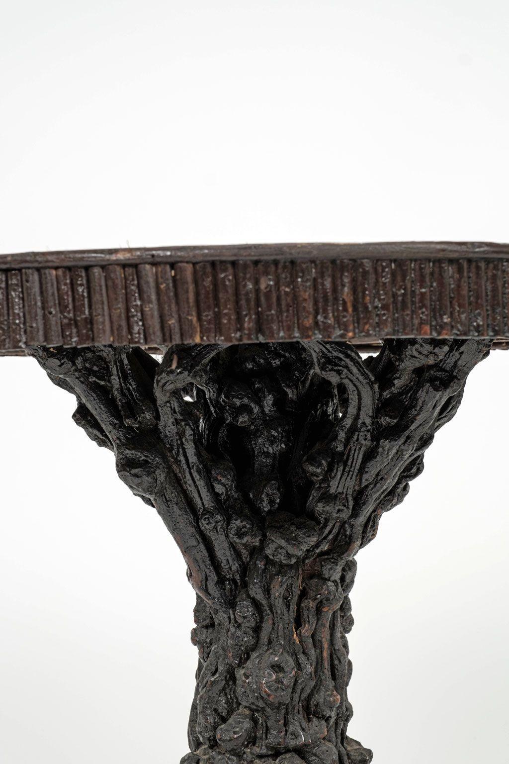 Guéridon rustique d'art populaire fabriqué à la main vers 1880-1910 en France. Cette table centrale d'art populaire est composée d'éléments naturels à la texture rugueuse. Une base en bois de racines noueuses soutient un plateau rond de taille