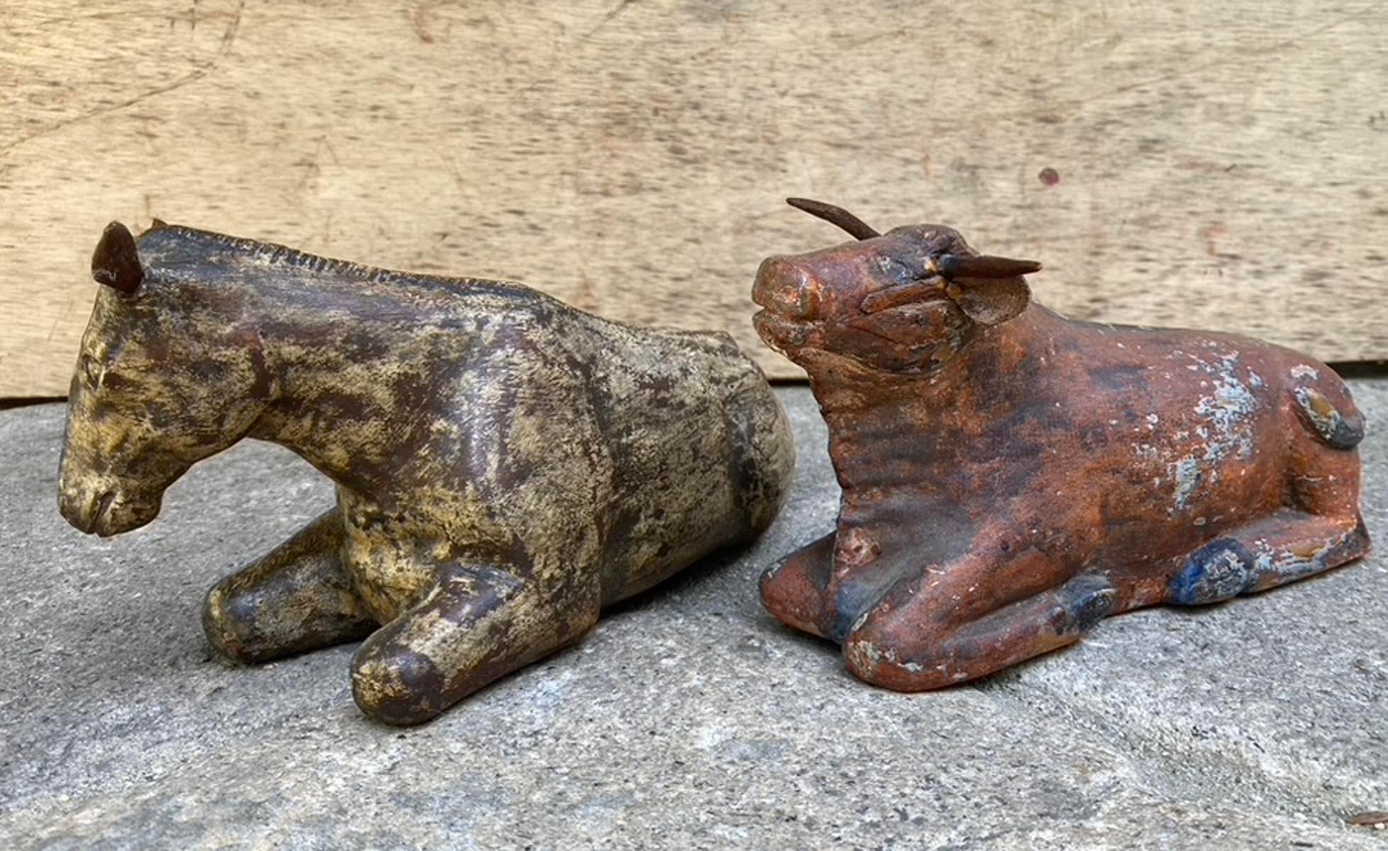 Pair of 19th century Guatemalan carved wooden nativity animals, depicting a recumbent horse and ox. Both figures retain traces of their original polychrome - the horse in mottled cream and brown, shows simple incised detailing to the mane, while the