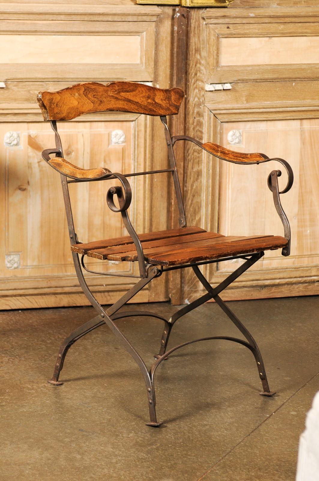 A rustic French Napoléon III period wood and iron garden folding chair from the mid 19th century, with curving arms and slatted seat. Created in France at the end of Emperor Napoléon III's reign, this rustic garden chair features an open back with