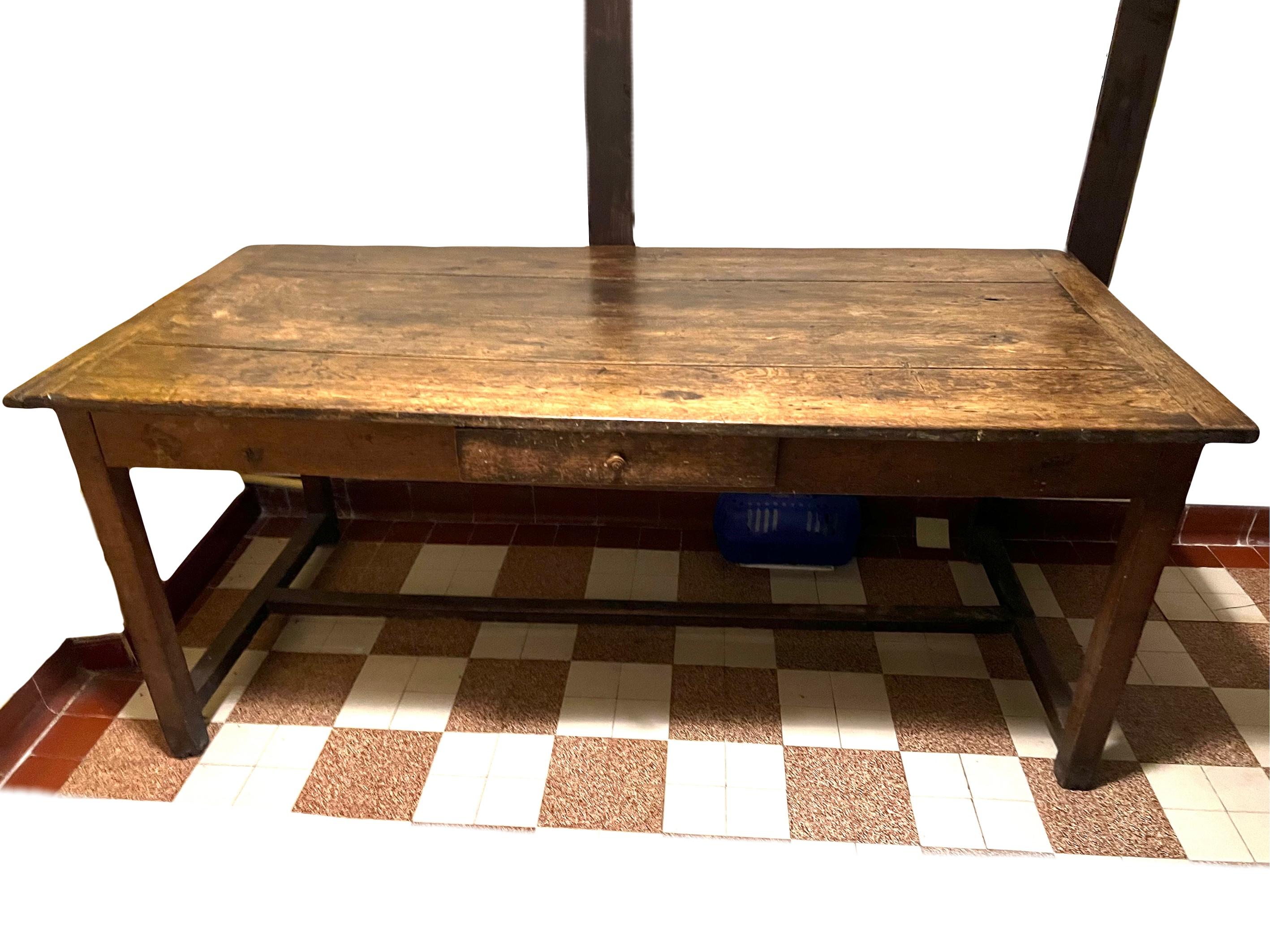 Period table, imbued with a rustic elegance that evokes the charm of grand farmhouse or monastic tables from yesteryears. Its naturally aged patina, beautifully worn, reveals a lengthwise drawer and another widthwise, even providing the option to