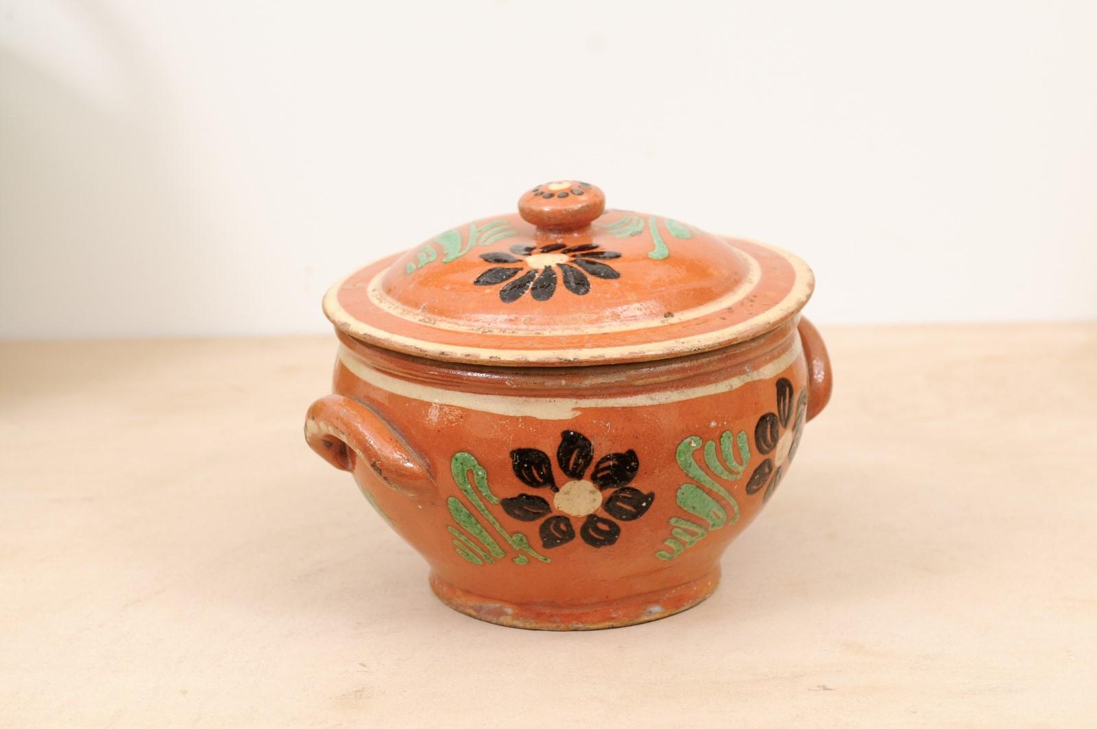 A French rustic glazed terracotta covered baking dish from the 19th century, with brown and green floral décor. Created in France during the 19th century, this covered baking dish features a circular lid topped with a petite handle, sitting above a