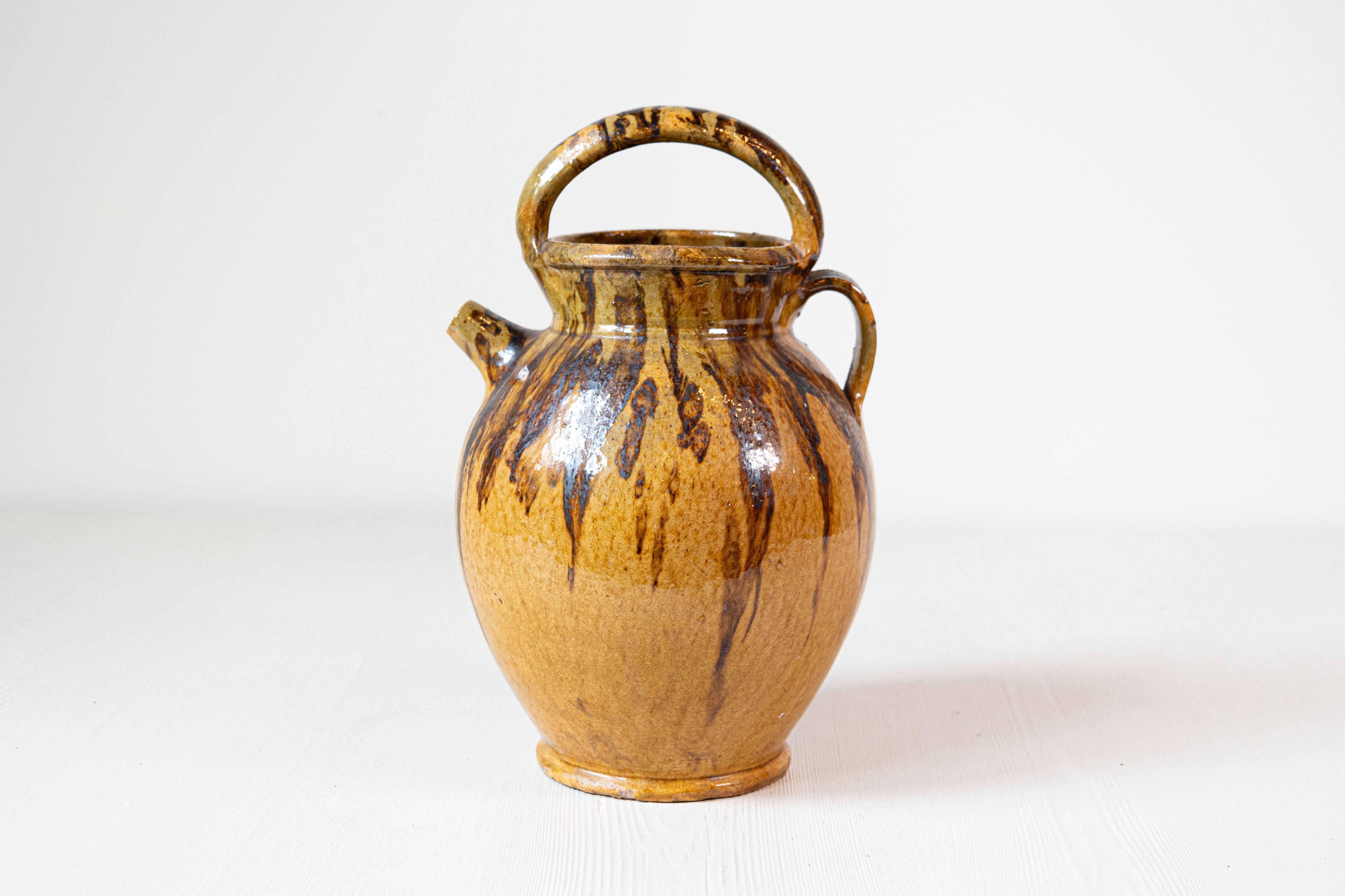 Verseuse à huile d'olive rustique en poterie française du 19e siècle avec bec avant, grande poignée supérieure et arrière. Cette cruche à huile d'olive en poterie française rustique du XIXe siècle dégage une irrésistible allure d'antan et témoigne