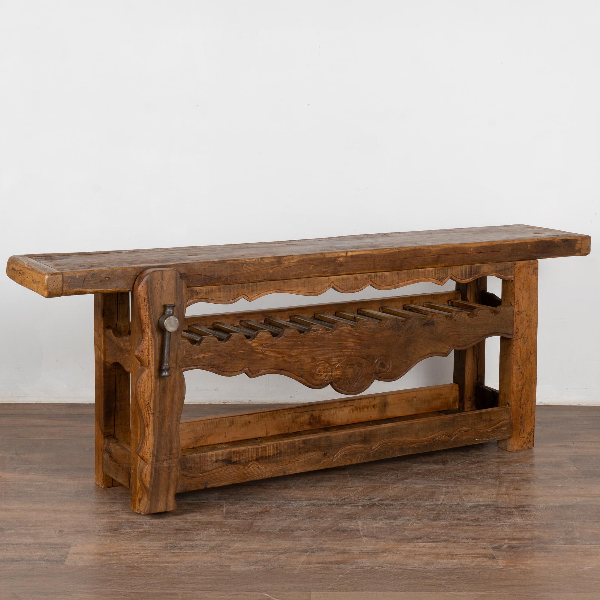 It is the years of constant use revealed in every ding, gouge, deep crack, and scratch that enrich the character of this impressive carpenters' workbench from France.
Unique to this console is the (newer) two shelves with the upper serving as a wine
