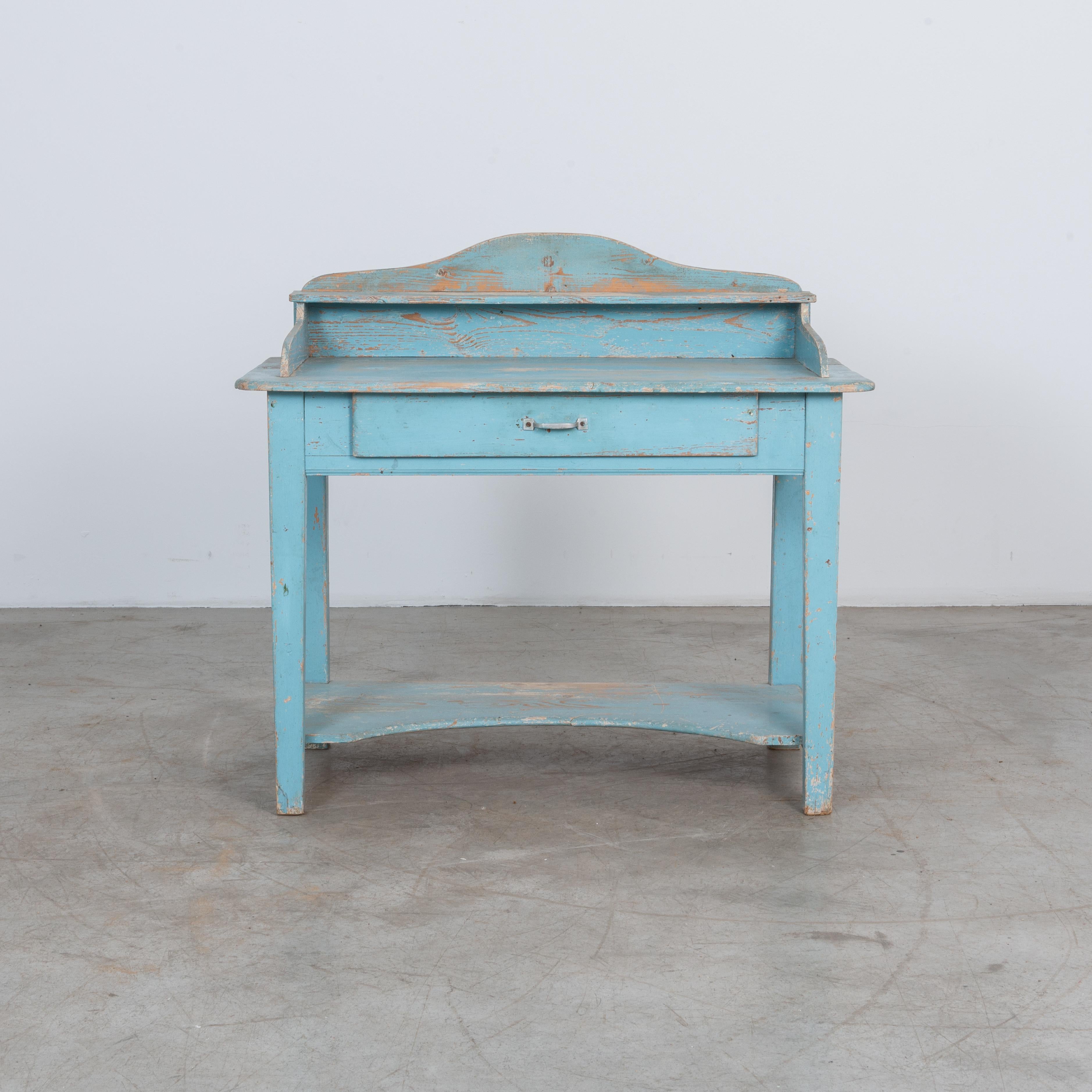 A colorful blue farm table from France, circa 1900. Used as a casual desk or a place to get ready, this charming table features an indented lower shelf, spacious drawer and practical wooden surround. An organizational asset with a splash of color,