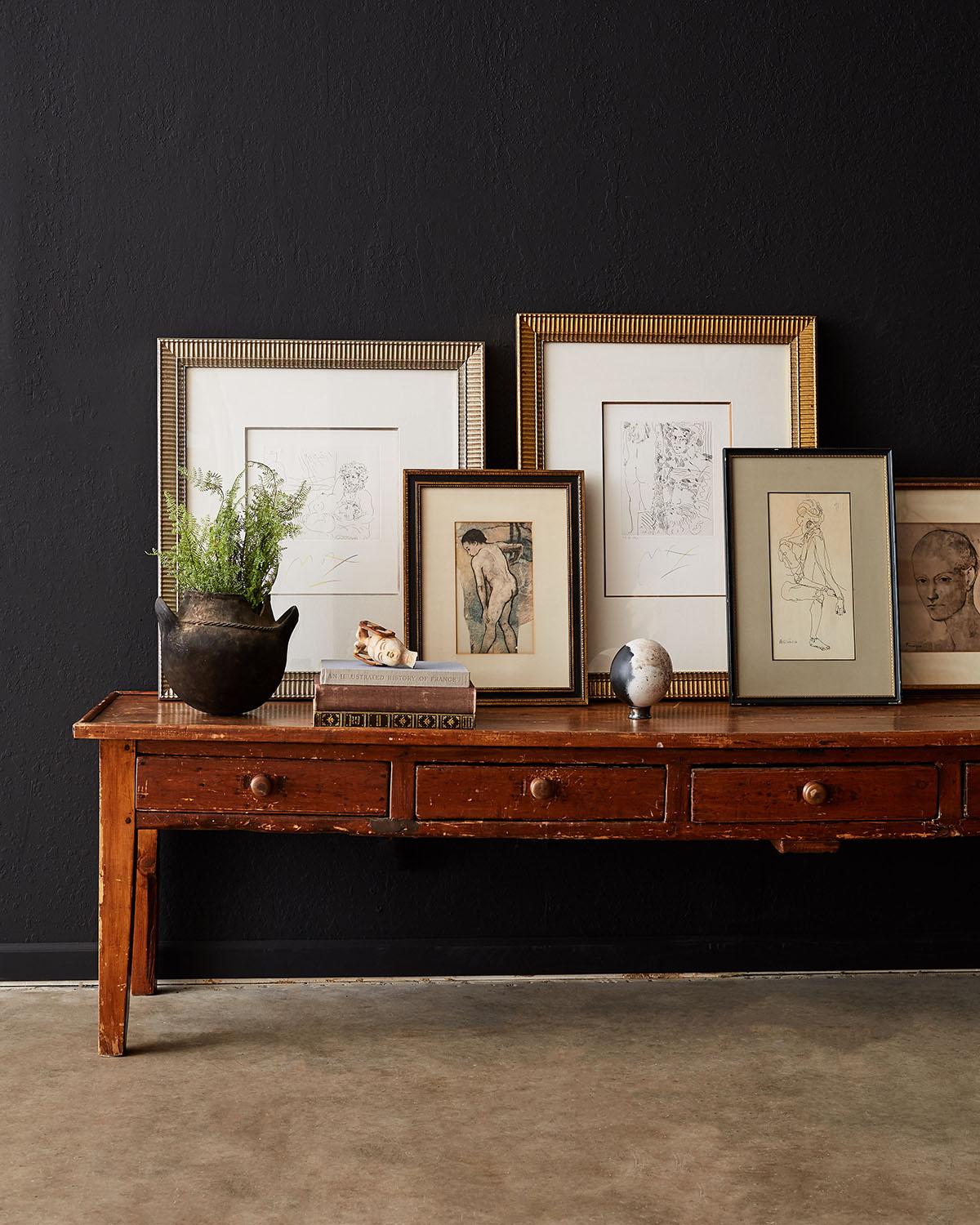 Massive rustic French country farmhouse table from early 19th century. Constructed from pine, originally used as a work table and was probably cut down sometime in its past. Fronted by five large drawers and made with mostly wood peg construction.