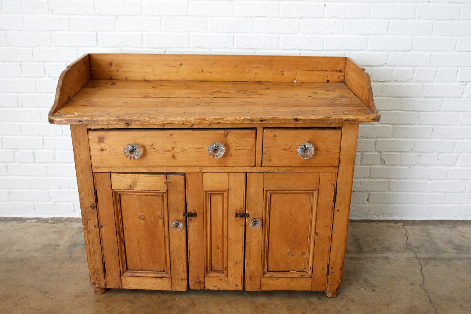 19th century rustic pine washstand or cabinet from a country French farmhouse. The galleried top measures 32 inches high with ample room. Features an aged, distressed patina on the pine with a warm finish. Fronted by two drawers on top and two doors