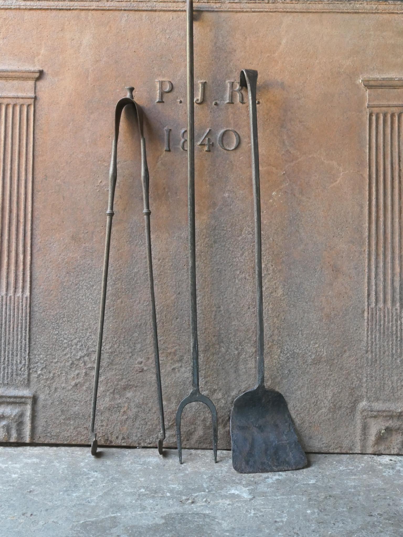 Rustikales französisches Kaminbesteck aus dem 17. bis 18. Jahrhundert. Das Werkzeugset besteht aus einer Feuerzange, einer Schaufel und einer Feuergabel. Die Werkzeuge sind aus Schmiedeeisen gefertigt. Das Set ist in einem guten Zustand und für den