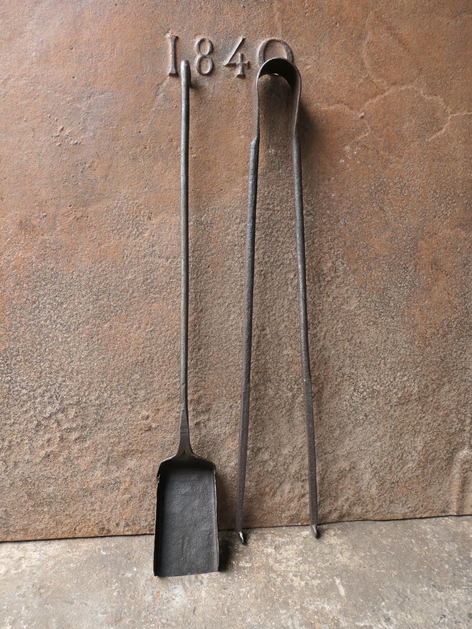 Rustic 17th-18th century French fireplace tool set. The tool set consists of fireplace tongs and a shovel. The tools are made of wrought iron. The set is in a good condition and fit for use in the fireplace.