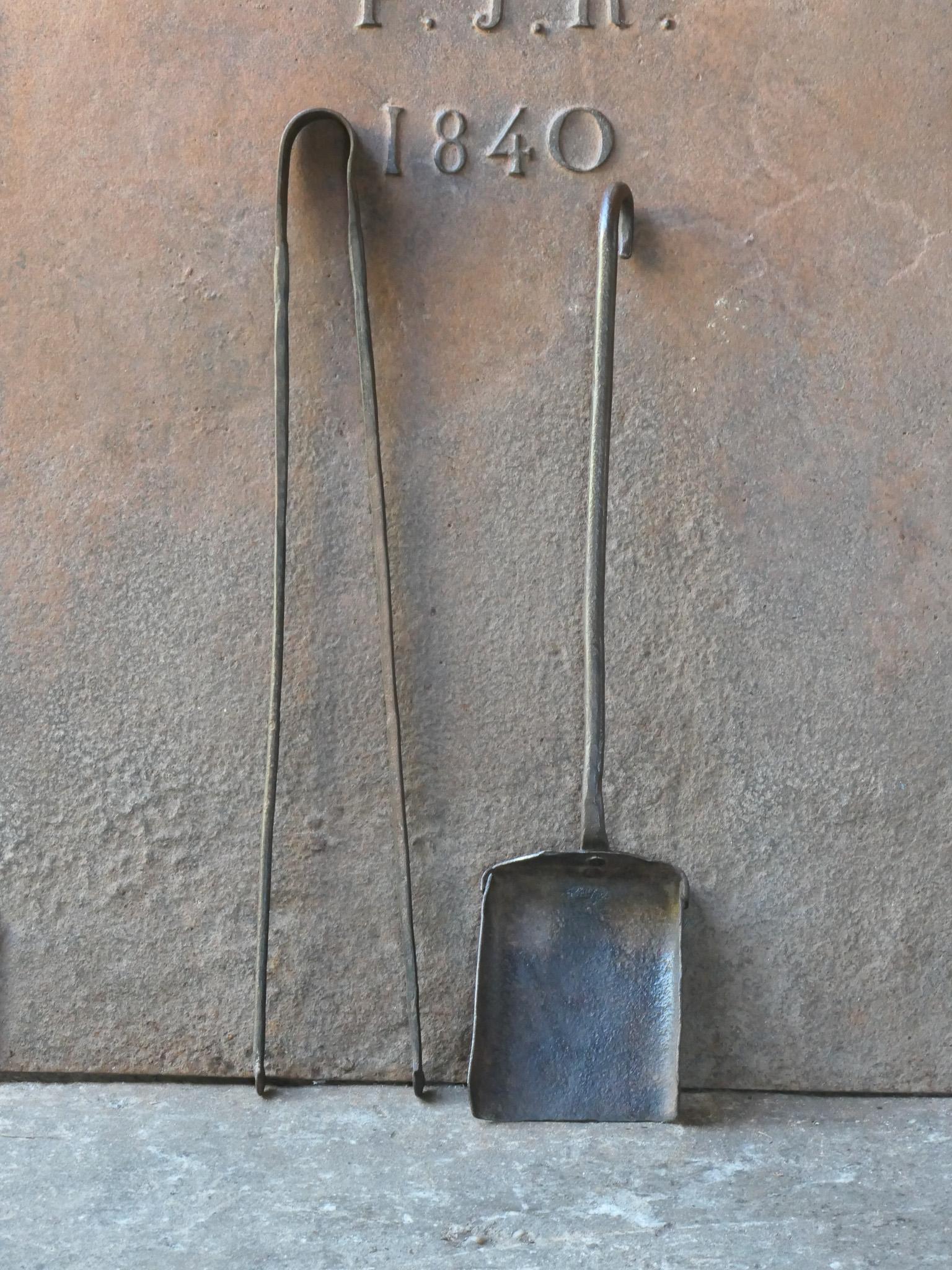 Rustic 18th-century French fireplace tool set. The tool set consists of fireplace tongs and a shovel. The tools are made of wrought iron. The set is in a good condition and fit for use in the fireplace. 