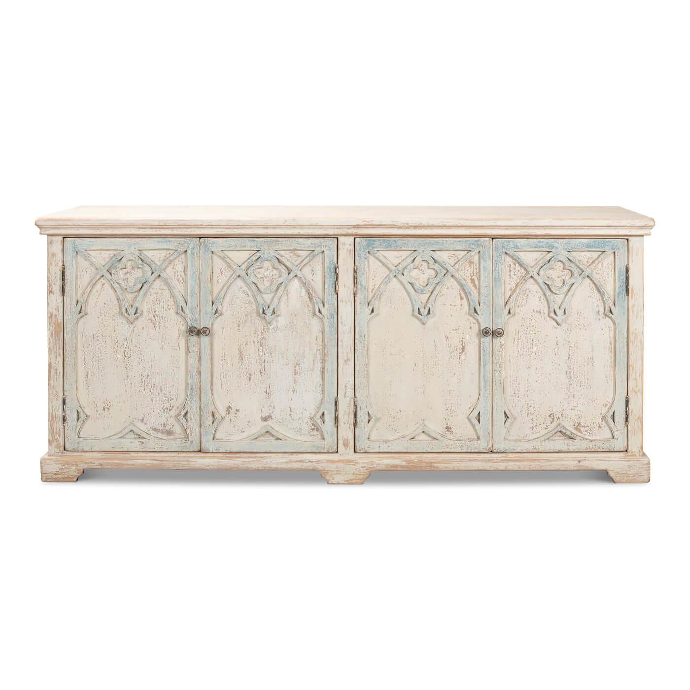 A Rustic French Gothic cabinet. This cabinet has four doors featuring a gothic arch design. A beautiful statement piece, perfect to use as a cabinet or sideboard. 

This piece is crafted in pine and features an antique whitewashed blue finish.