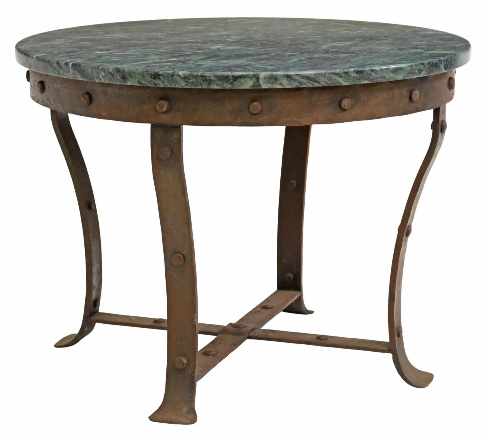 Rustic French marble and iron coffee table, 20th c., having round marble top, over curved stretcher-joined legs, with rivet accents.

Dimensions: approx 18.25