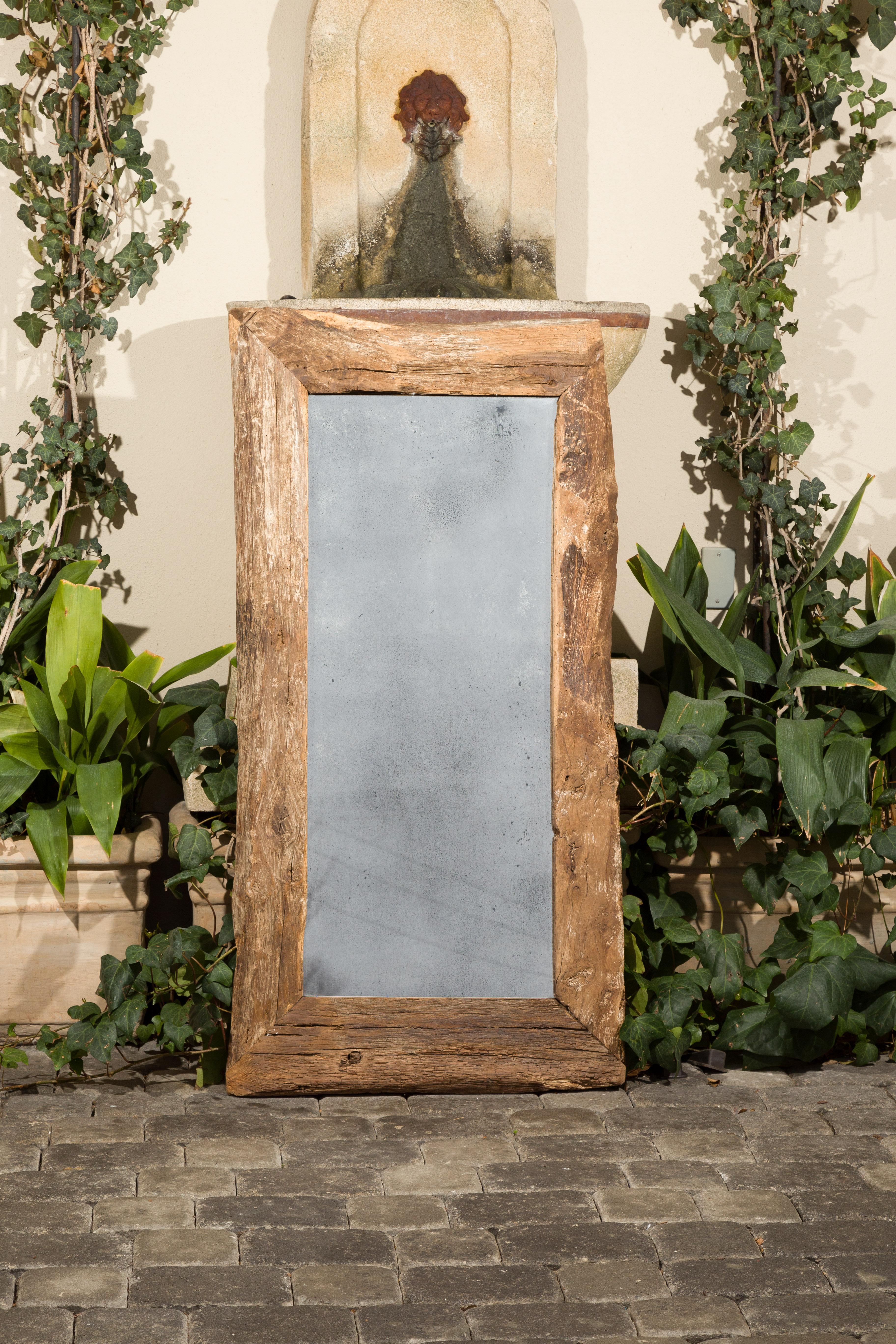 A French rustic mirror made from mid-19th century wood, with antiqued glass. Created in France with wood from the 1850s, this rectangular mirror captures our attention with its rustic silhouette and nicely worn appearance. Showcasing an antiqued